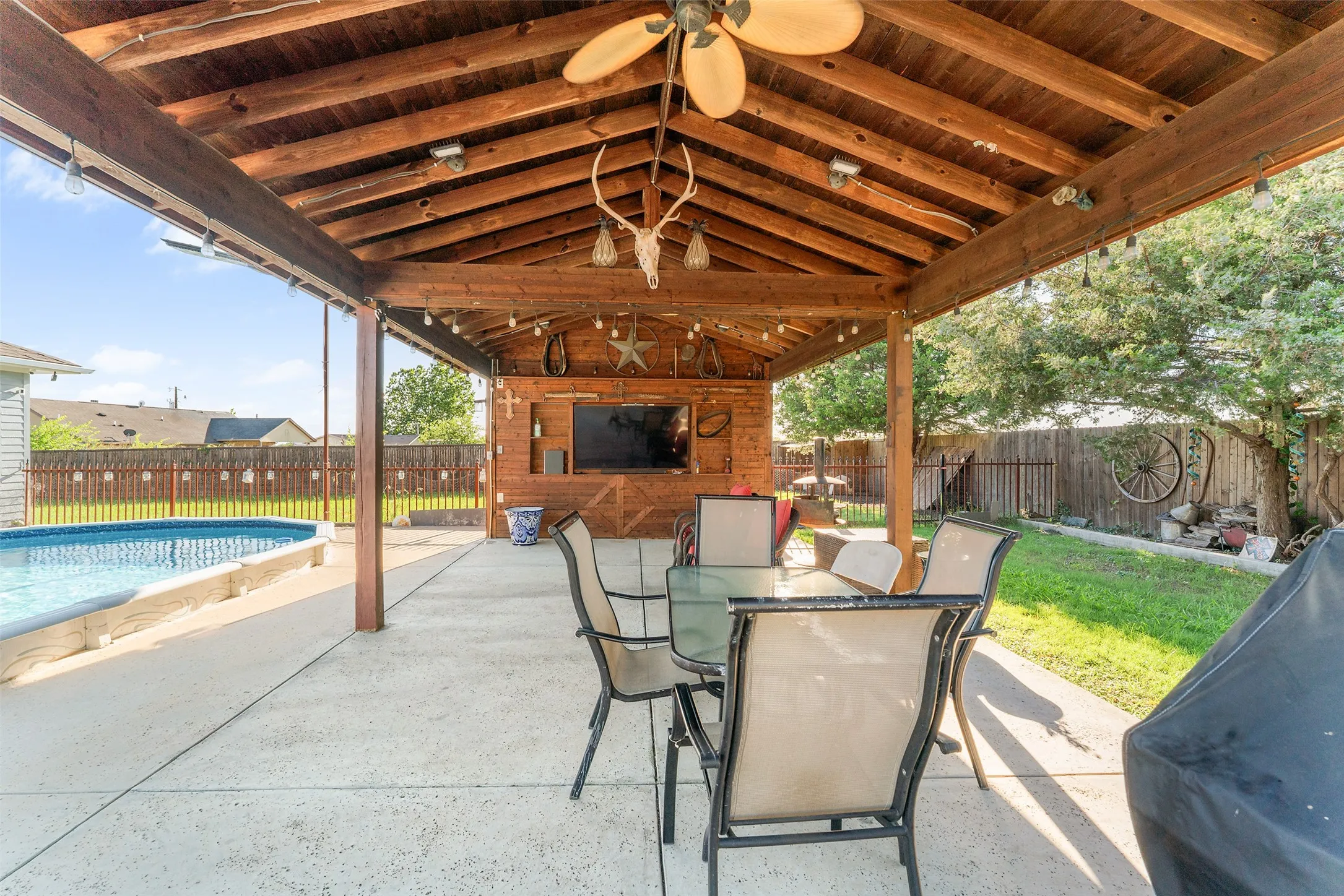 Spacious covered patio featuring a wood-plank ceiling, ceiling fan, and recessed lighting