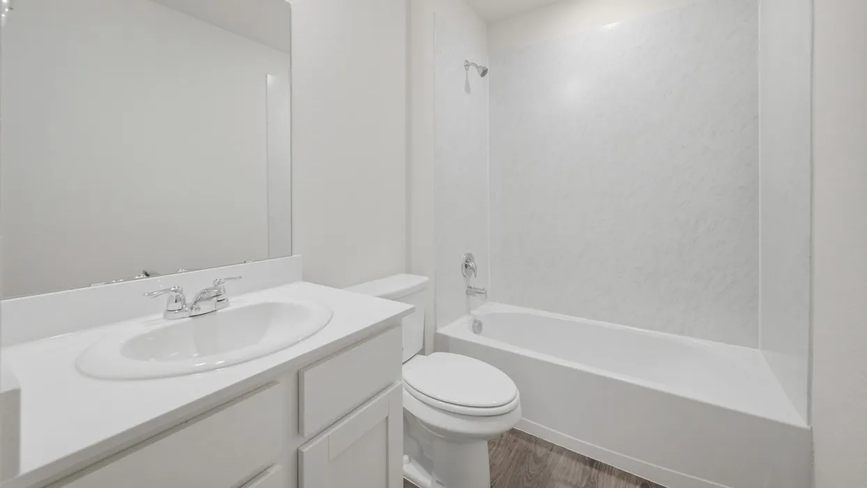 Bathroom featuring a single vanity with an integrated sink, chrome faucet, and a wall-mounted mirror