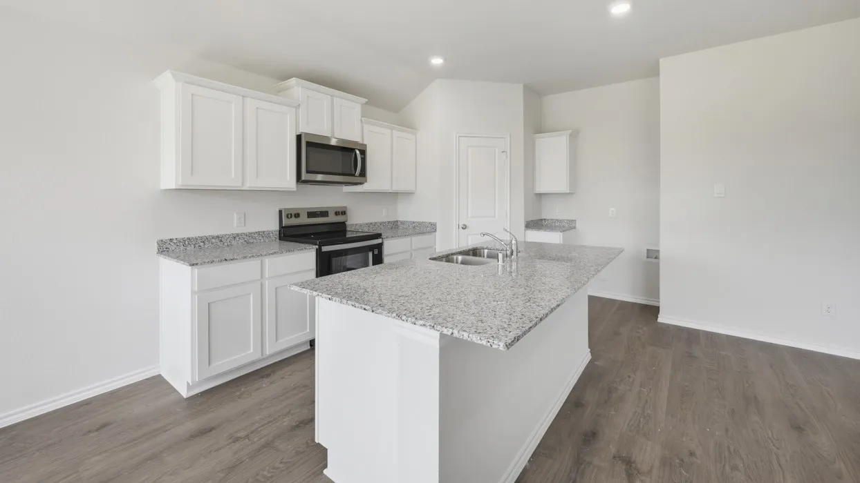 Kitchen featuring white cabinetry, granite countertops, stainless steel appliances, a center island with an undermount sink, and wood-finish flooring