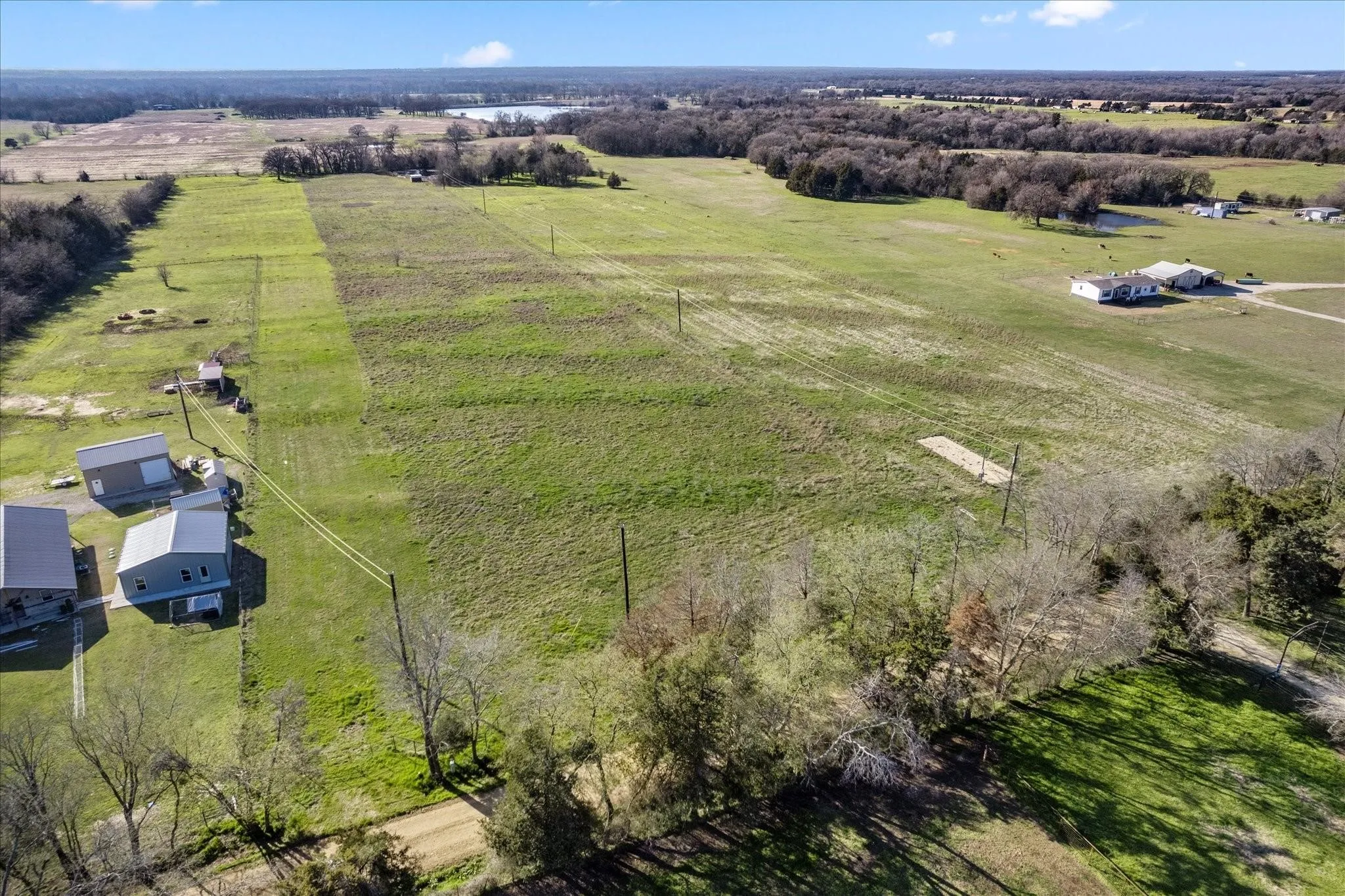 Expansive land parcel featuring open fields and distant structures