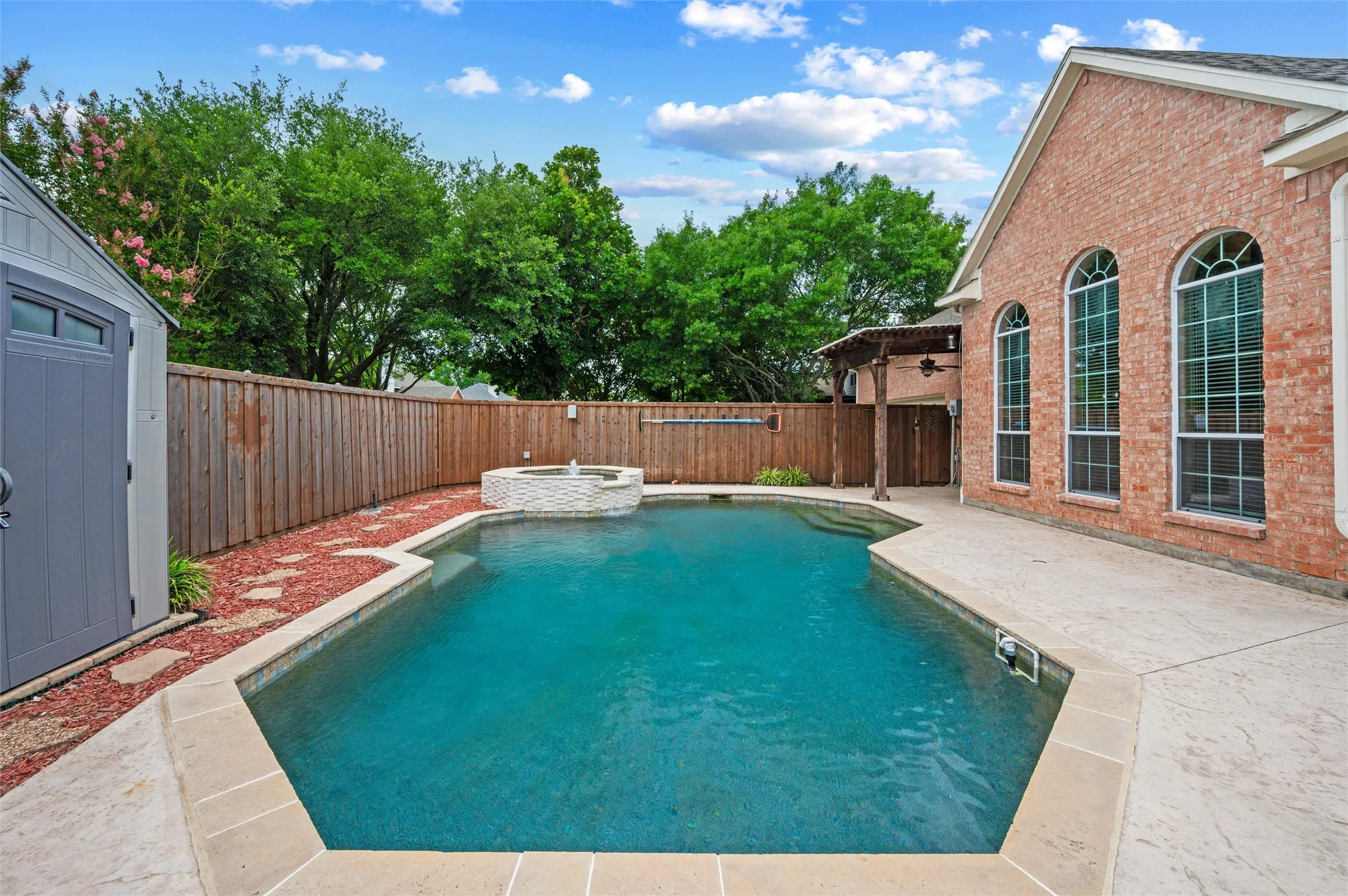 Large area for sun bathing - pebble tech pool - auto refil - fountain and waterfall on the spa - storage bldg to hte left for pool supplies - board on board privacy fence