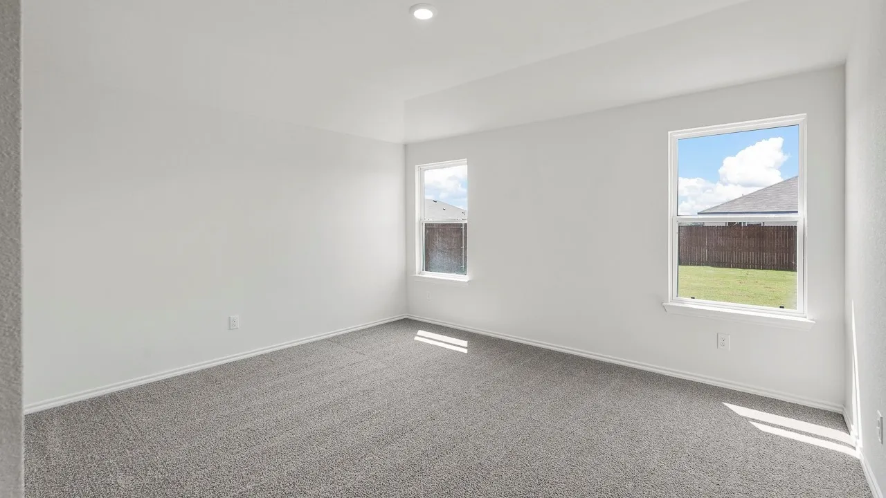 Spacious room featuring neutral paint, gray carpeting, dual windows, and recessed lighting