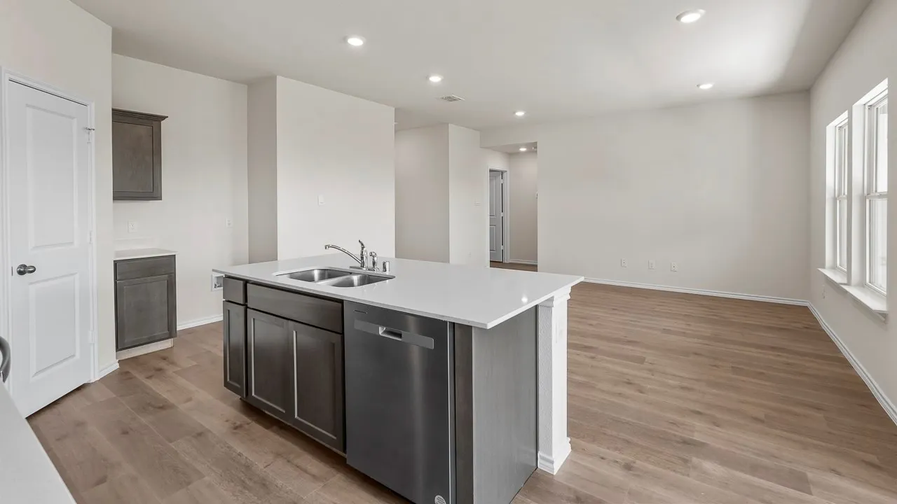 Kitchen island featuring a double-basin sink and stainless steel dishwasher