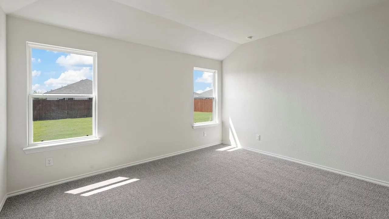 Bright interior space with two windows, vaulted ceiling, light-colored walls, and gray carpeting