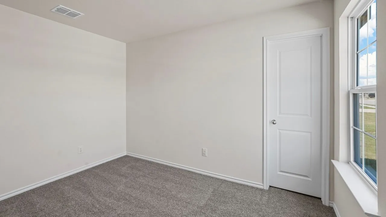 Neutral toned room with grey carpet flooring, white baseboards, and a white two-panel interior door