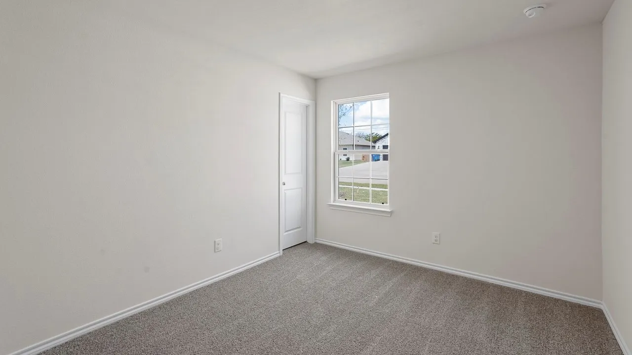 Bedroom featuring light gray walls, gray carpet, white trim, and a white framed window