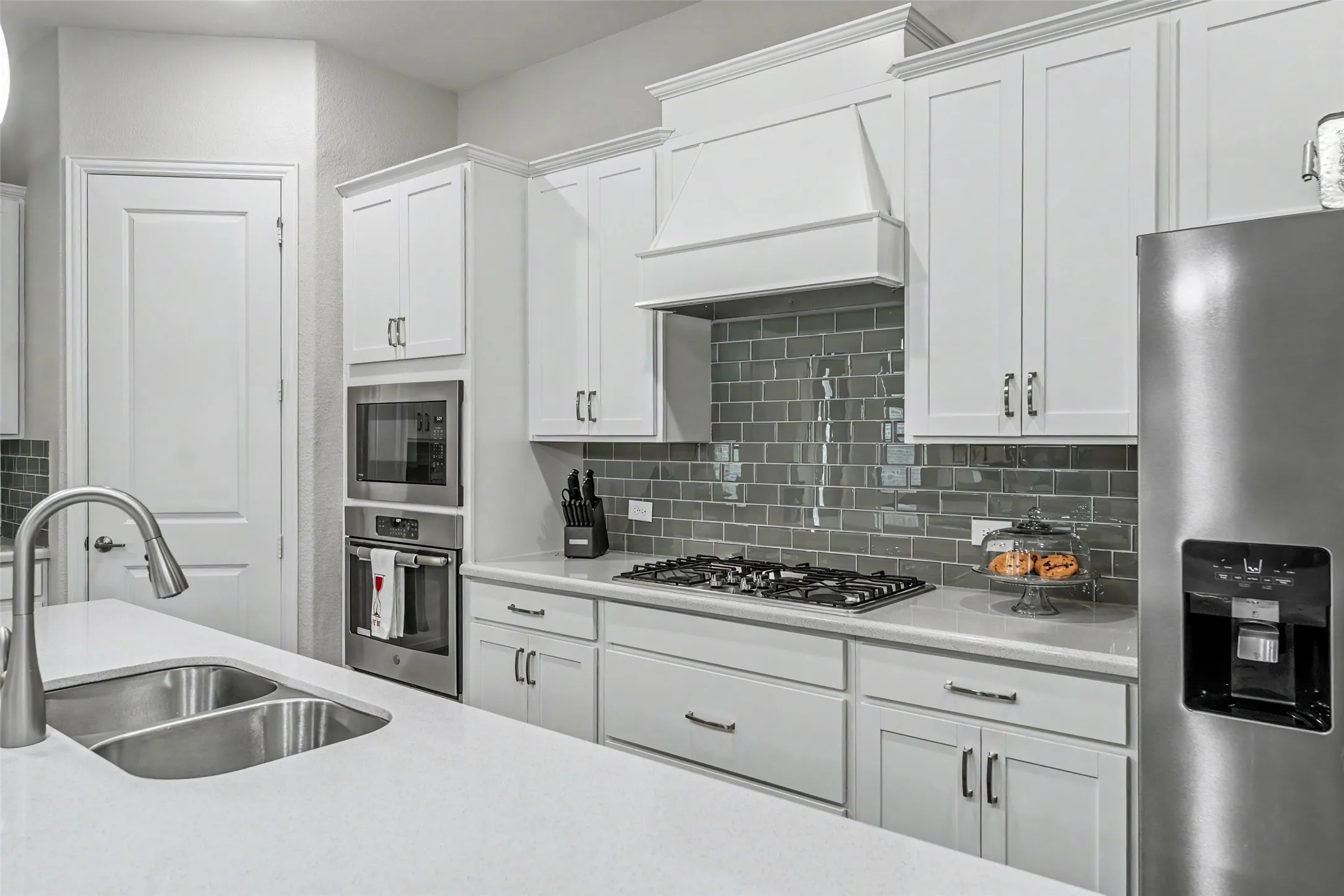Chef's kitchen showcases quartz countertops, abundant cabinetry, stainless appliances, gas cooktop, and a spacious center island.
