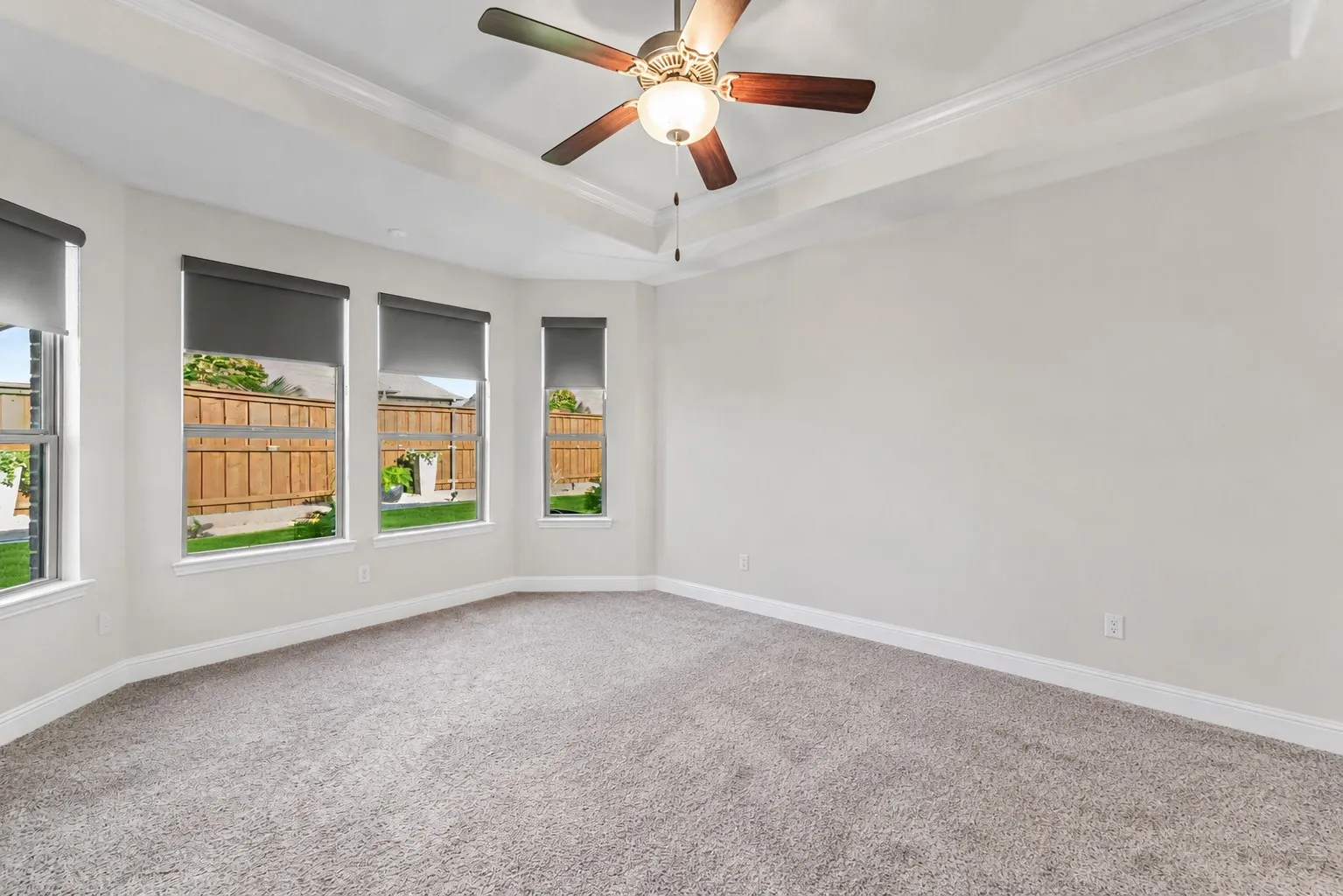 The generous primary retreat offers a peaceful escape with space for oversized furnishings and serene backyard views.