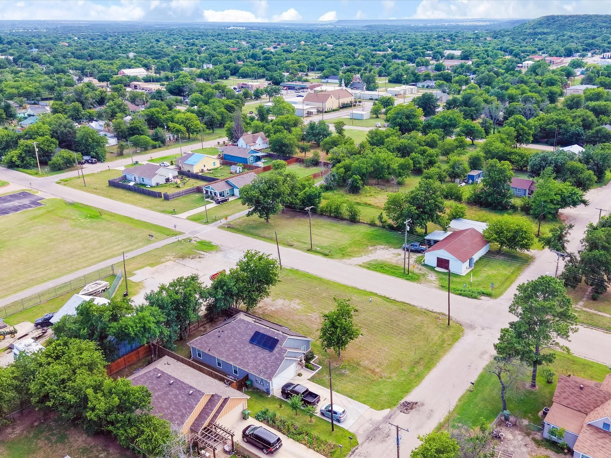 Aerial perspective showcasing a residential property with a dark shingle roof and solar panels