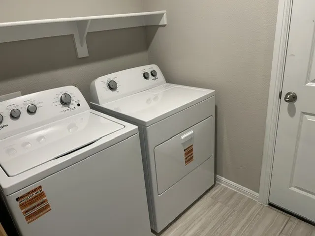 Whirlpool washer & dryer in the laundry room, located near the garage entrance.