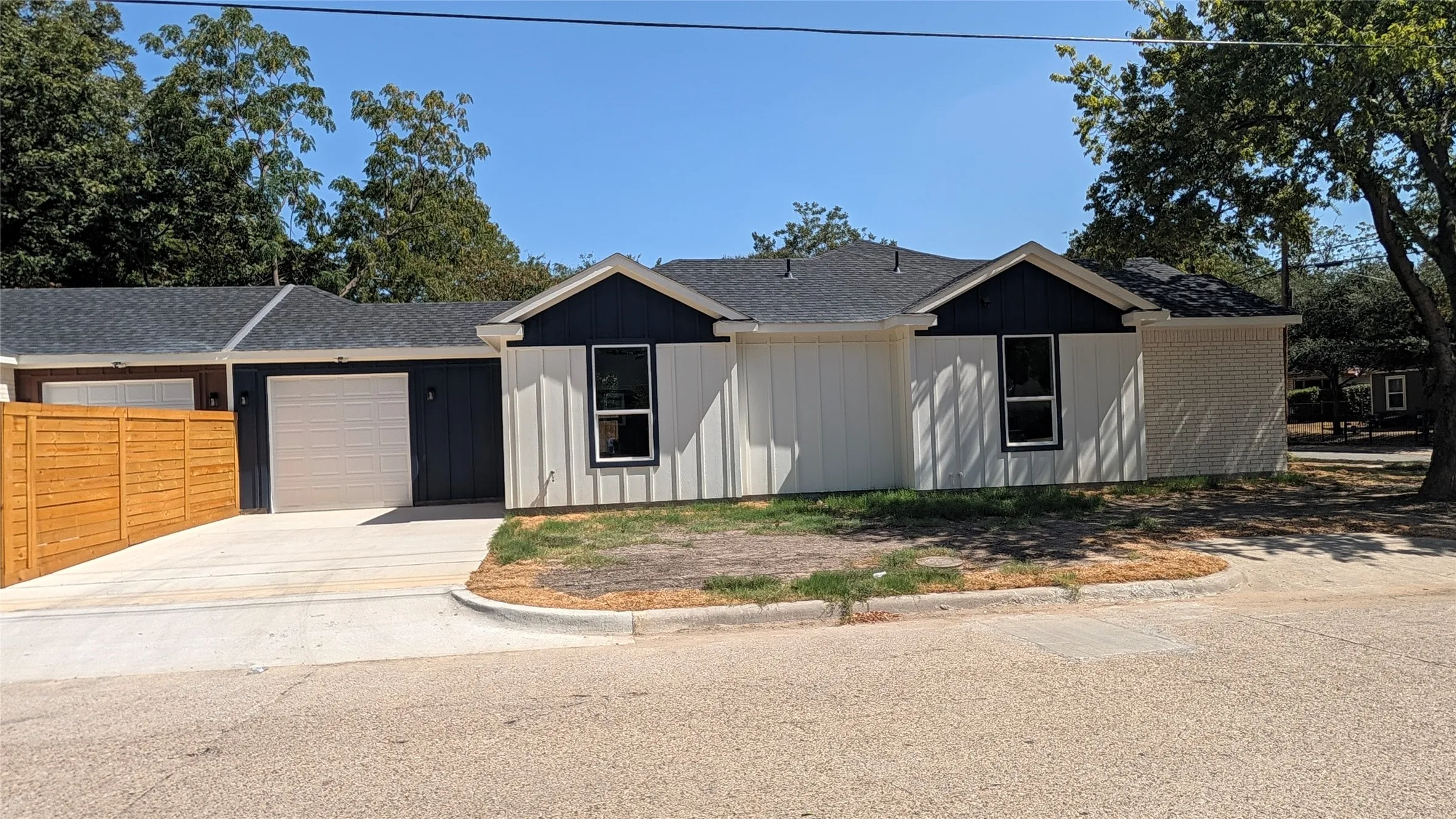 Contemporary exterior featuring vertical siding, board and batten accents, and a dark shingle roof