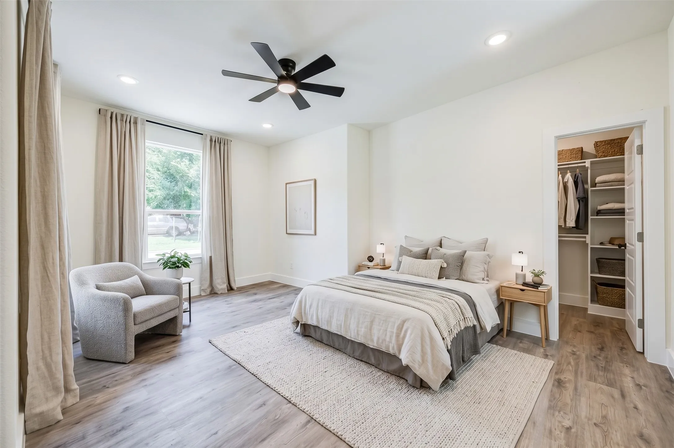 Neutral white walls, wood-finish flooring, recessed lighting, and a ceiling fan with integrated lighting