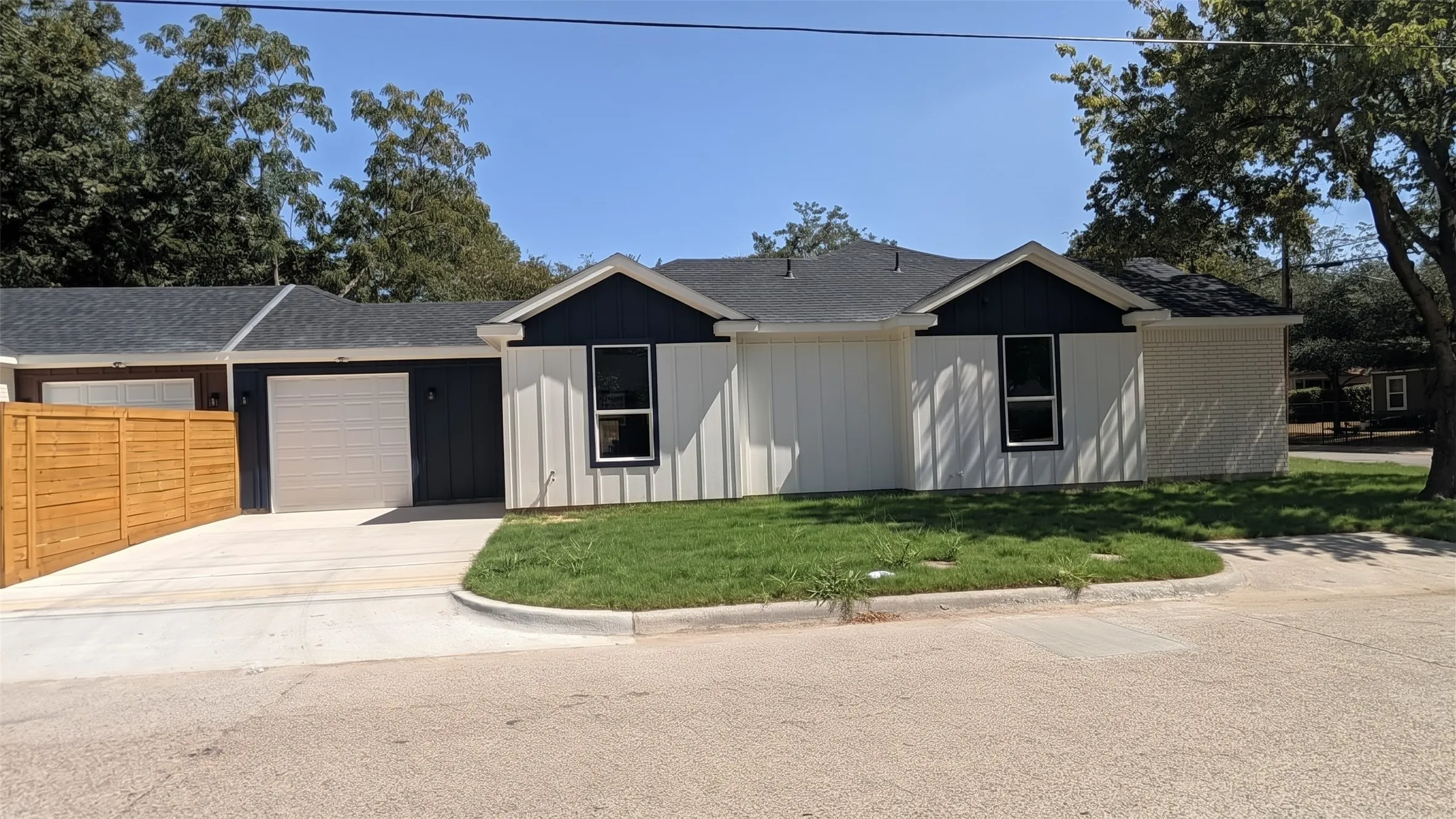 Single-story exterior with white vertical siding and dark trim accents