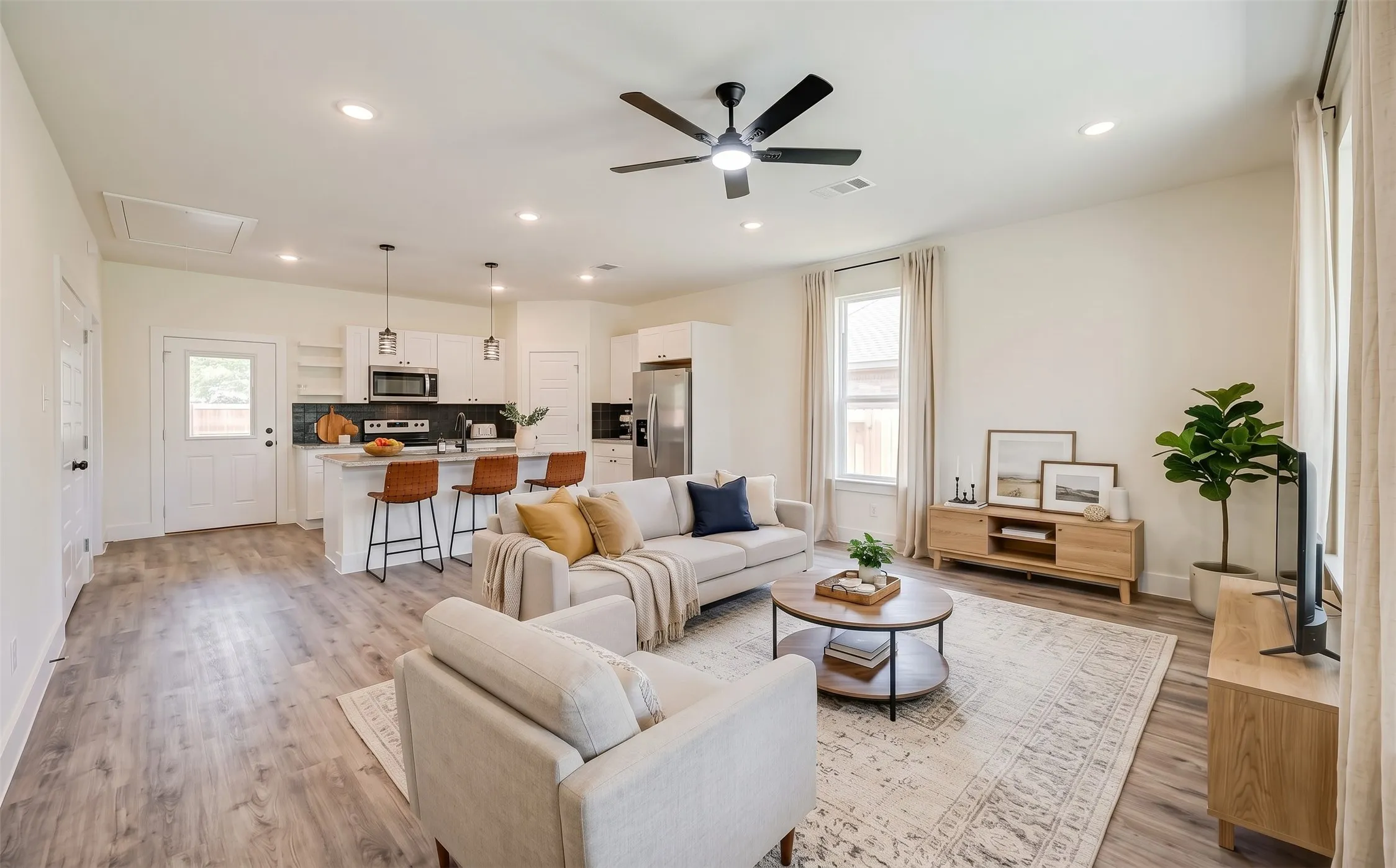 Open concept living area with wood-finish flooring, recessed lighting, and a ceiling fan