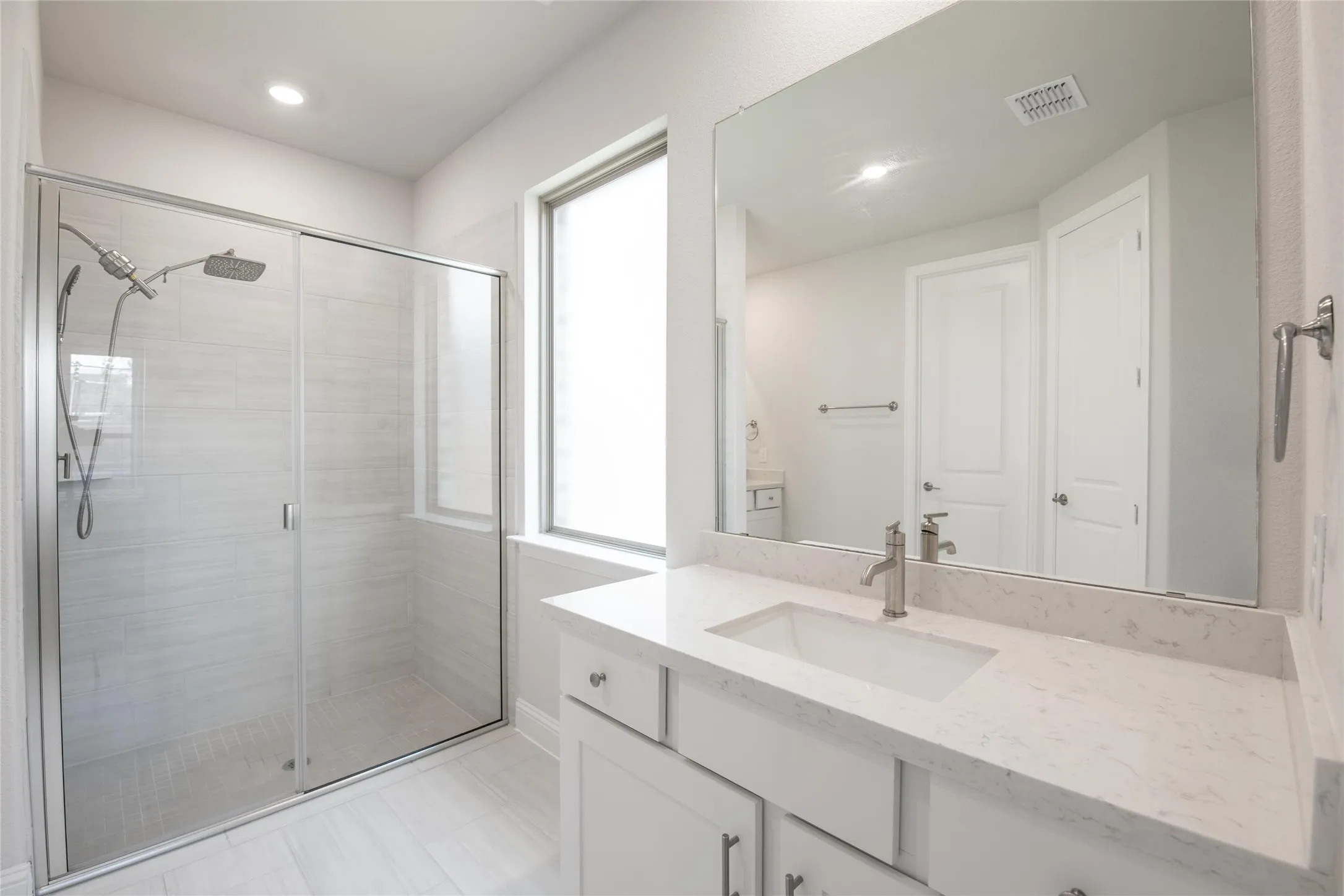 Start and end each day in this spa-inspired primary bath featuring an oversized walk-in shower, abundant counter space, and elegant finishes throughout.