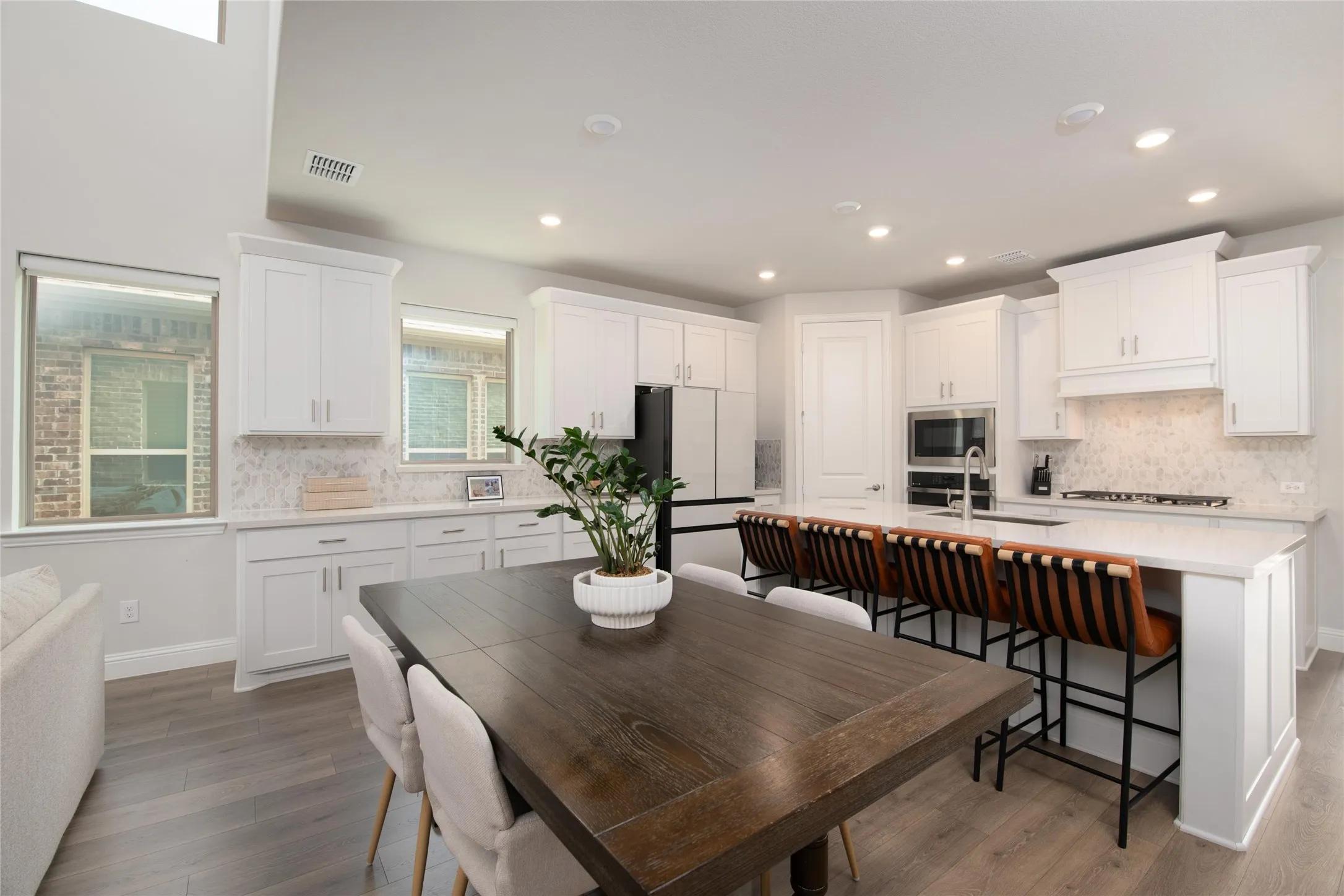 The spacious dining area is perfectly positioned between the kitchen and gathering room, creating a central hub for everyday meals, holiday celebrations, and memorable gatherings.