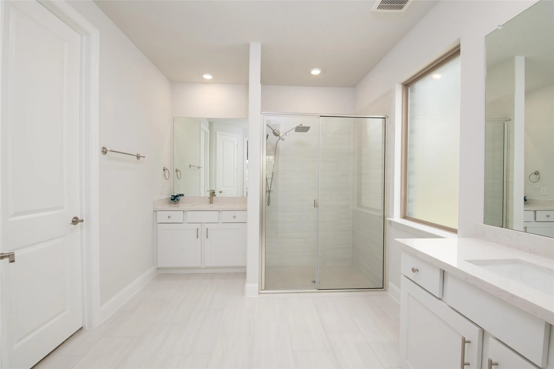 Separate his-and-her vanities provide convenience and personal space, while the expansive layout creates a luxurious owner's retreat experience.