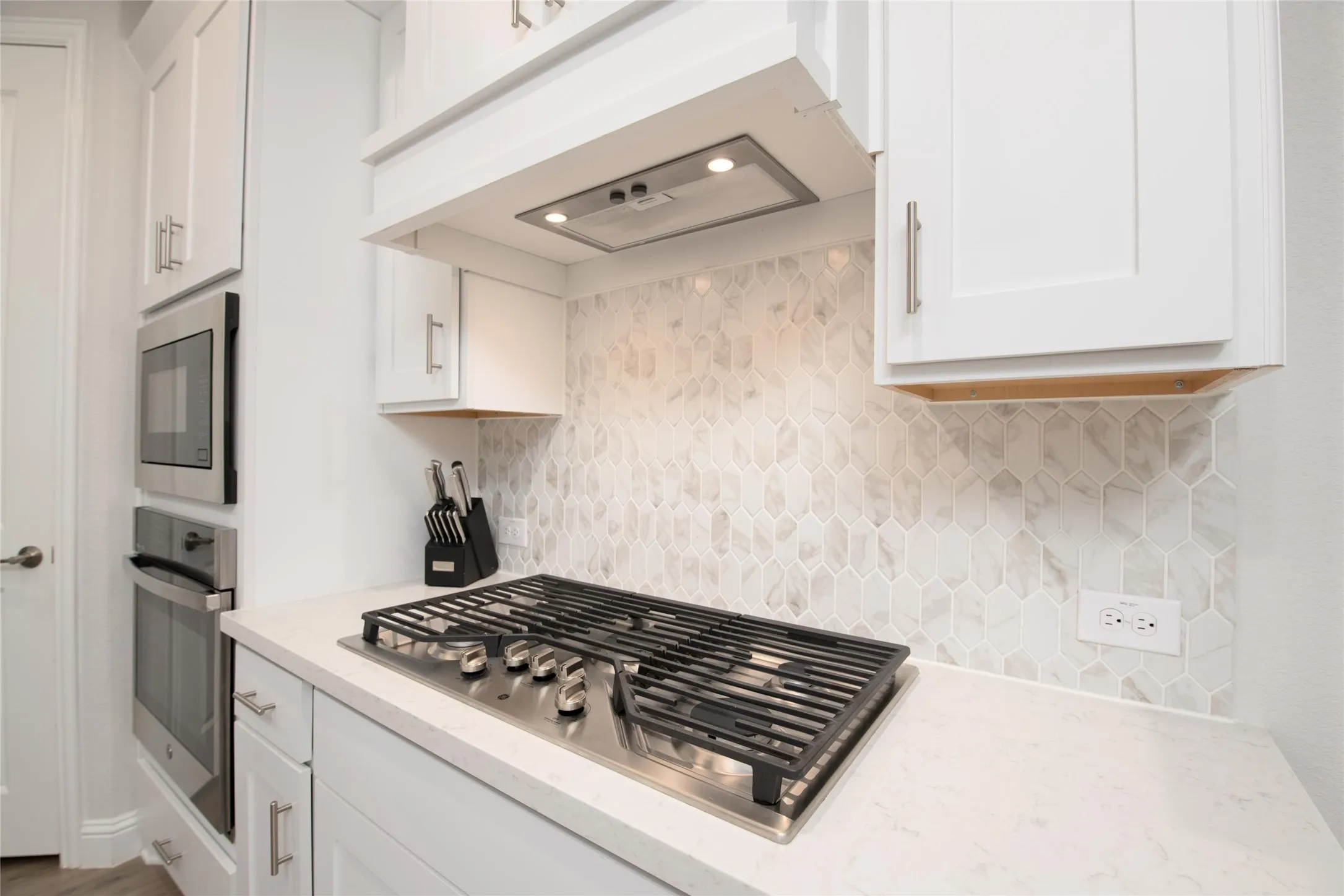 Prepare meals with ease using stainless steel appliances, a gas cooktop, custom vent hood, and designer tile backsplash that adds both style and function.