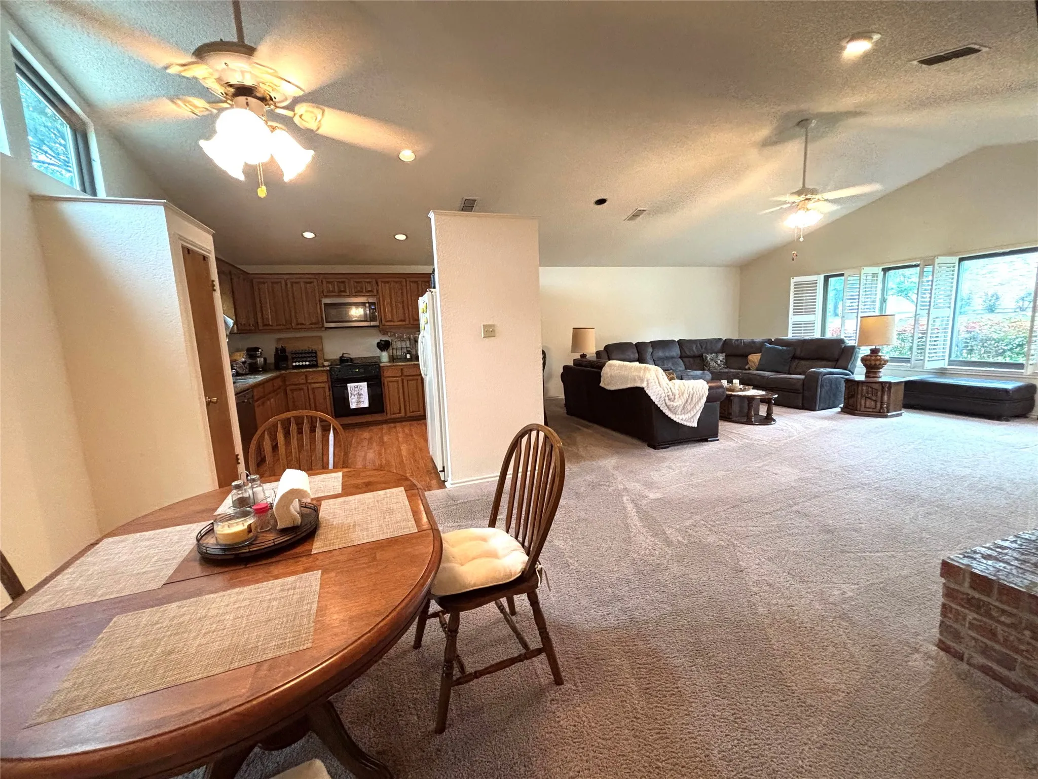 Expansive main living area featuring vaulted ceilings, recessed lighting, and numerous windows with plantation shutters