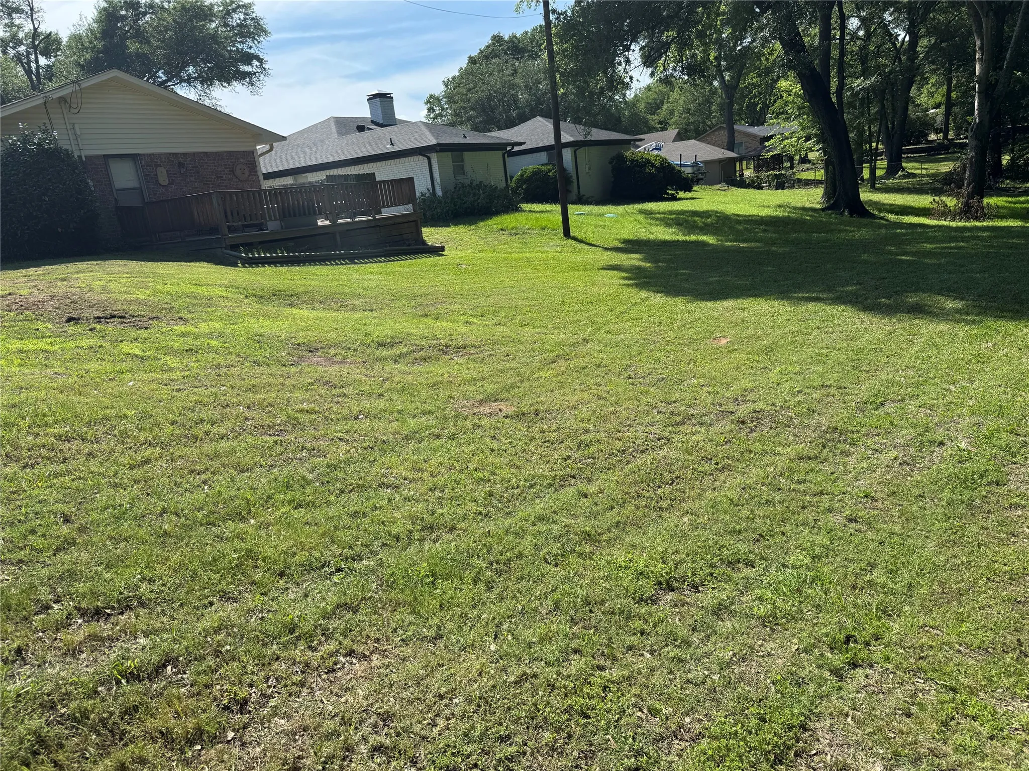 Expansive grassy area with a visible wood deck
