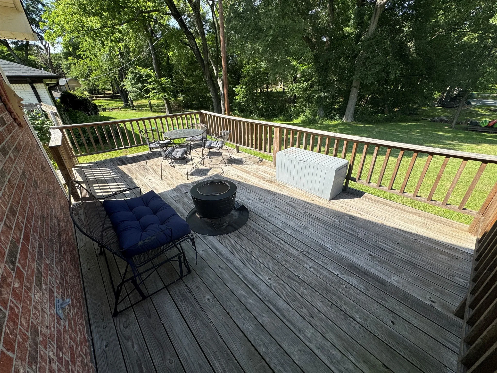 Wood deck with a natural wood railing off the primary.