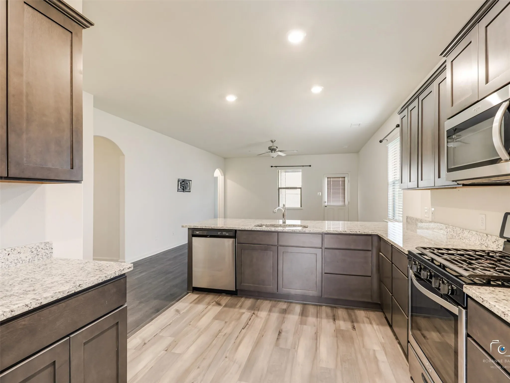 Kitchen featuring wood-finish flooring, granite countertops, and stainless steel appliances