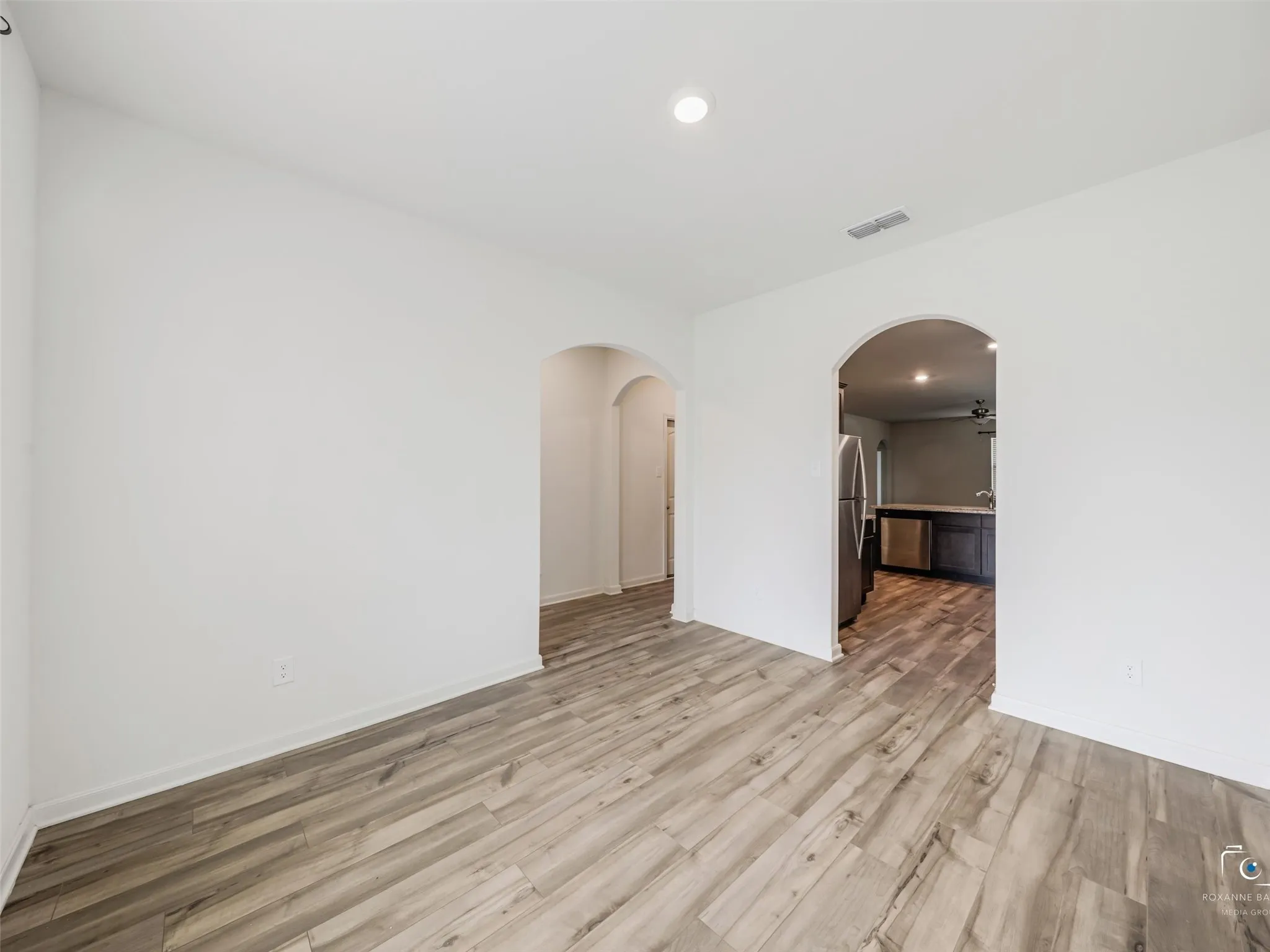 Archway entries, wood-finish flooring, recessed lighting, and white wall finishes