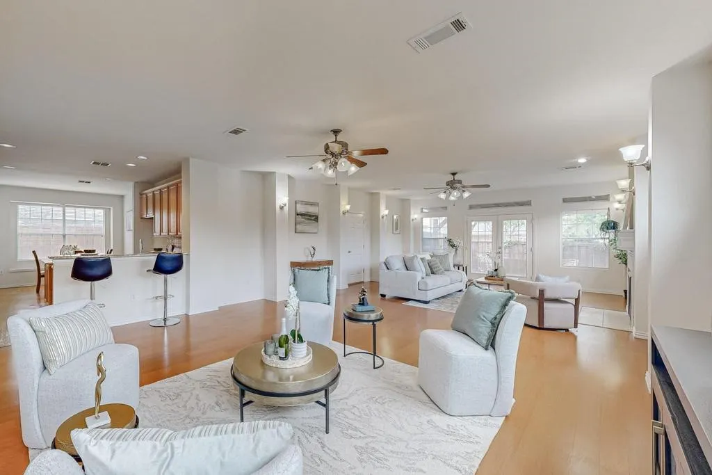 Spacious living area featuring wood-finish flooring, recessed lighting, and multiple ceiling fans