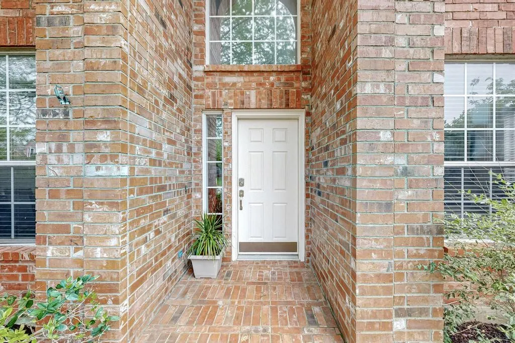 Traditional brick facade featuring a paneled entry door with sidelights and an arched transom window