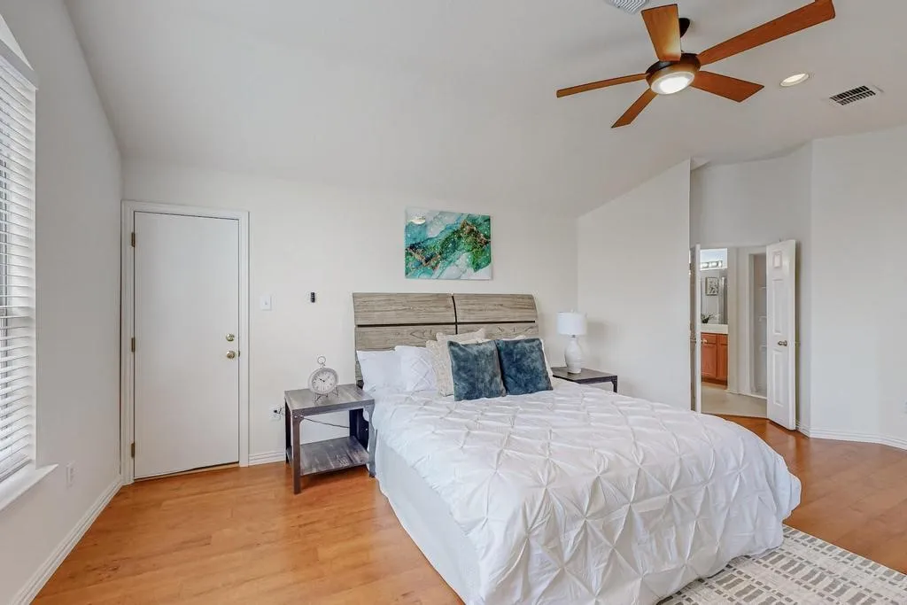 Spacious sleeping area featuring wood-finish flooring, a ceiling fan with integrated lighting, and recessed ceiling lights