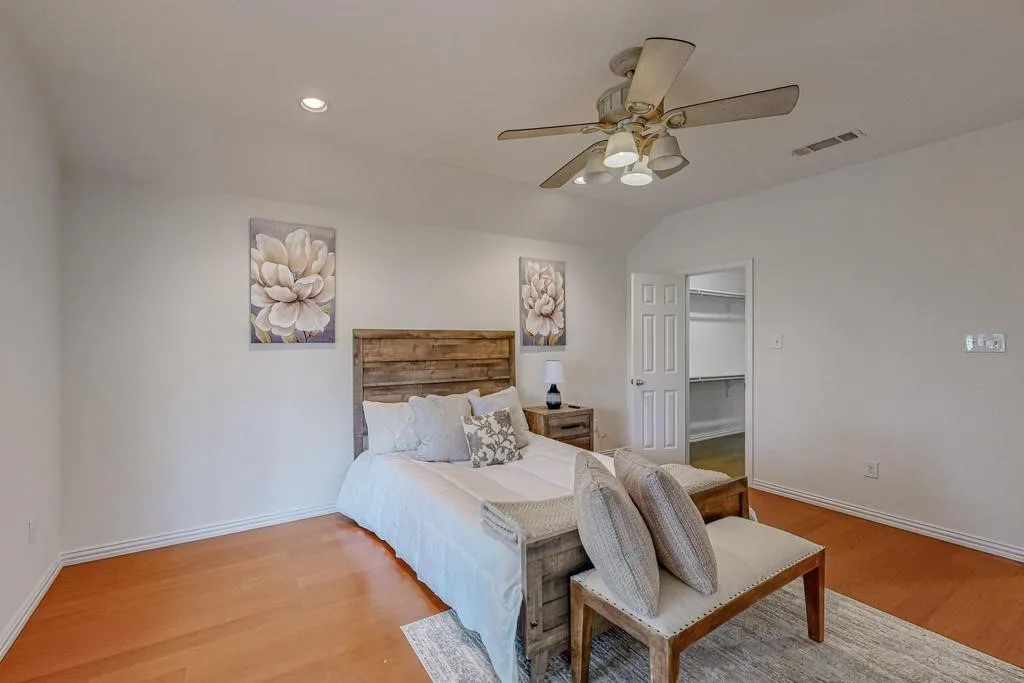 Bedroom featuring wood-finish flooring, a ceiling fan with integrated lighting, and recessed ceiling lights