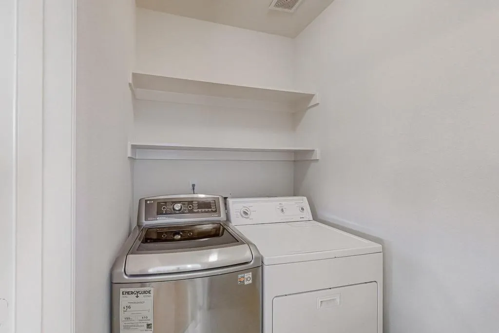 Utility area featuring white painted walls and two built-in shelves for storage