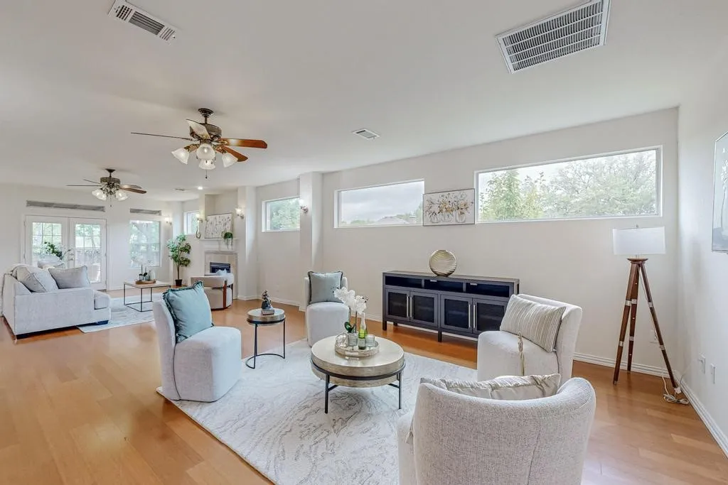 Expansive living area featuring wood-finish flooring, multiple windows, and a built-in fireplace