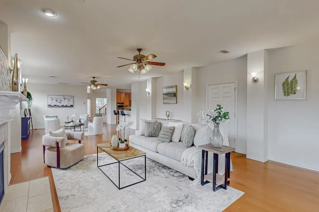 Open-concept living area featuring wood-finish flooring, recessed lighting, ceiling fans, and sconce lighting
