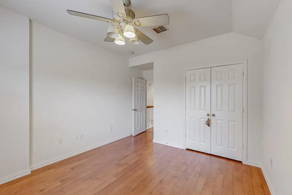 Room featuring wood-finish flooring, white baseboards, and a ceiling fan with integrated lighting
