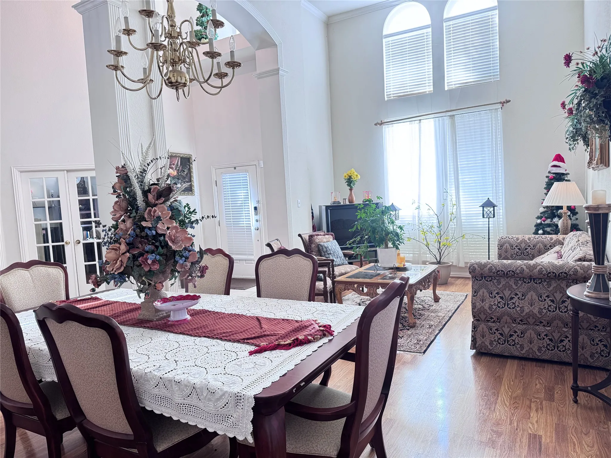 Two-story living area featuring a vaulted ceiling and a brass chandelier