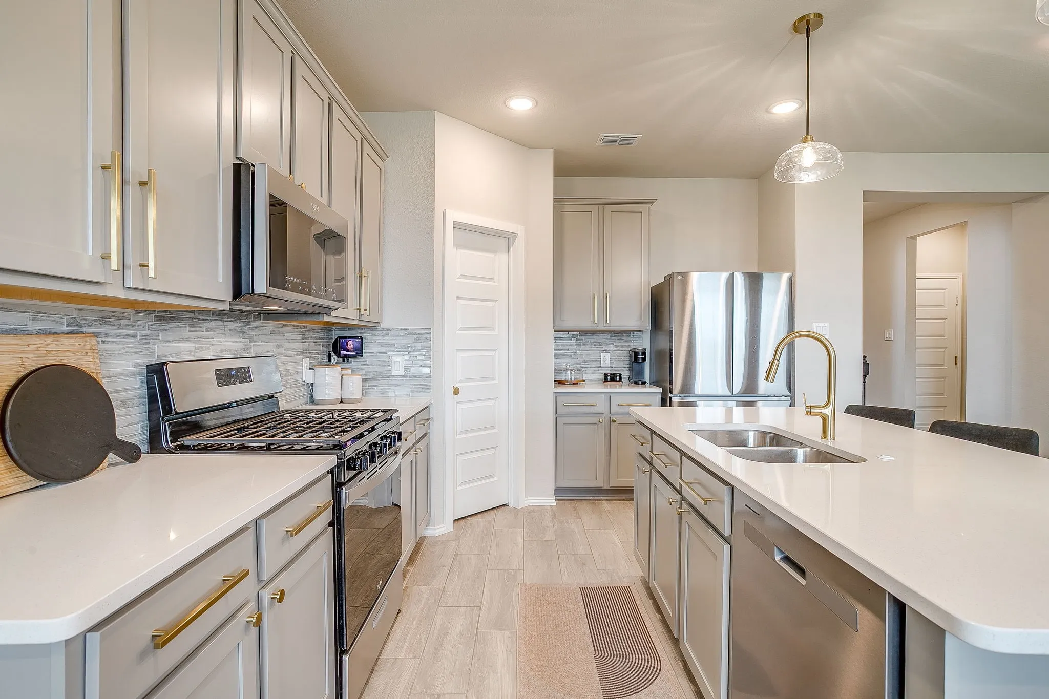 Quartz countertops, Gas cooking,  gold hardware and faucet.