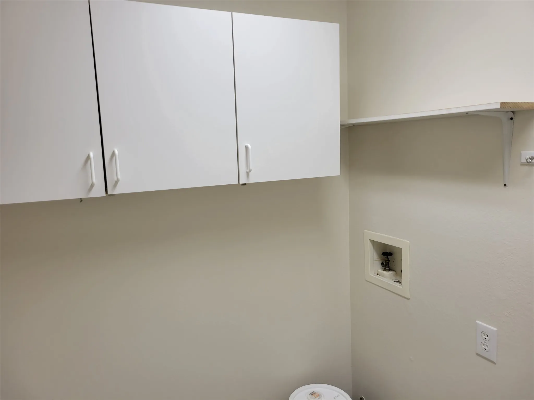 Laundry area with hookup for a washing machine and cabinets