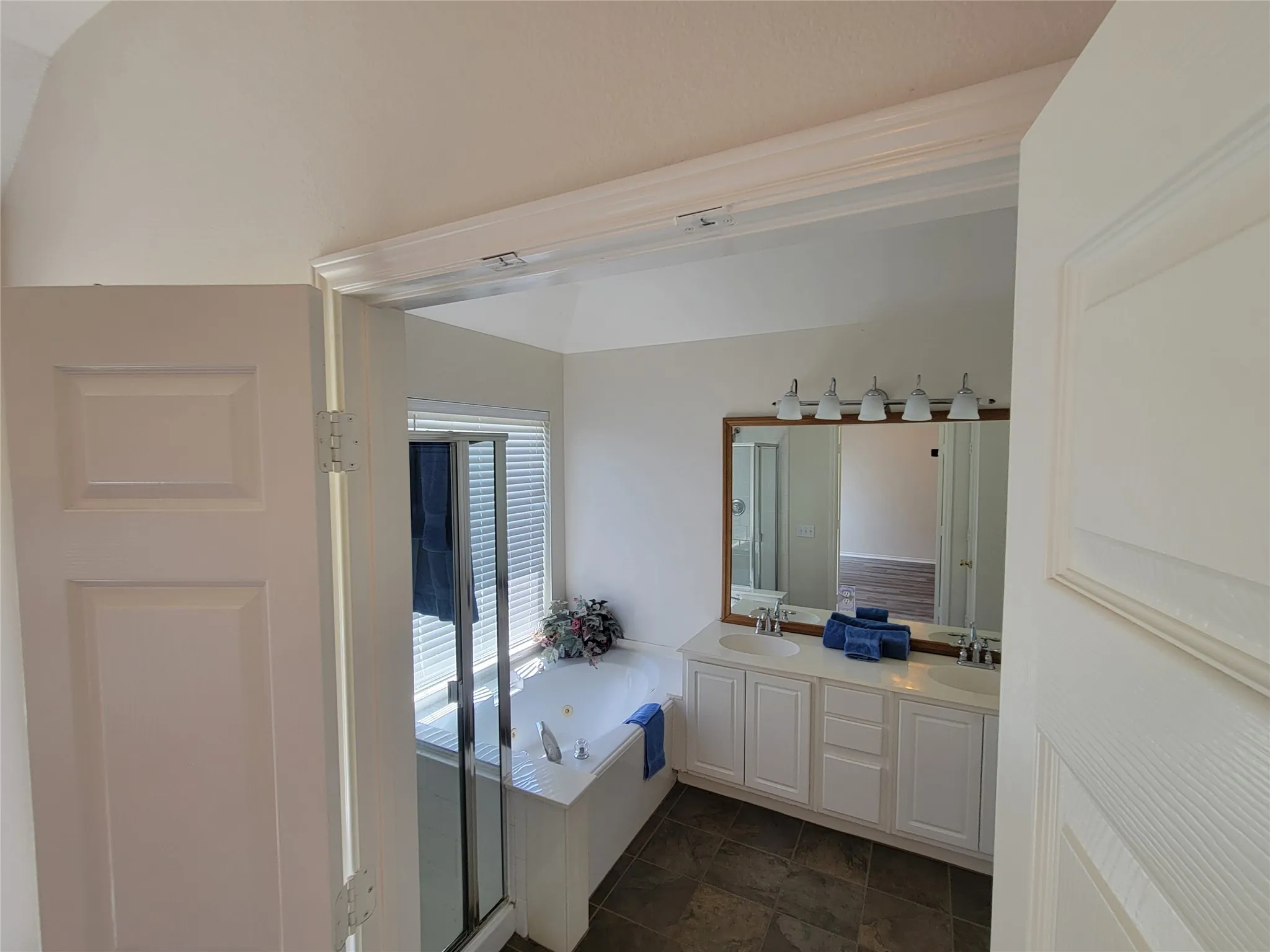 Bathroom featuring tile patterned flooring, separate shower and tub, and double vanity