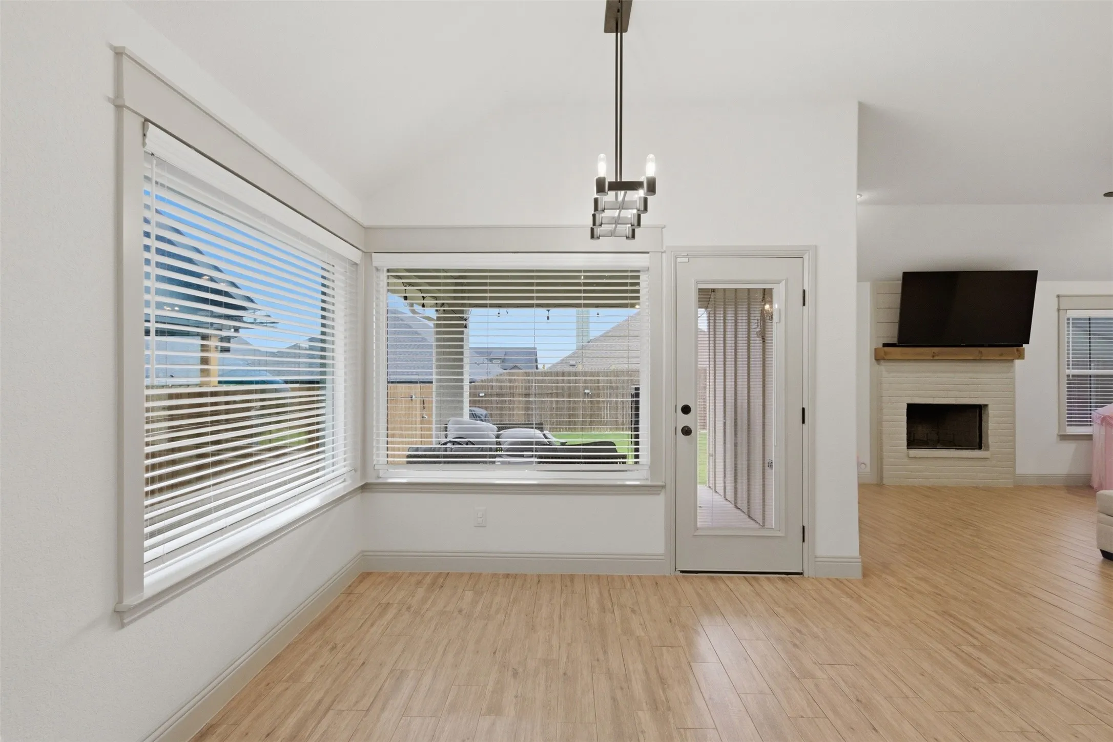 Dining area with picture windows looking out to your yard, hardwood laminate flooring, drop down light