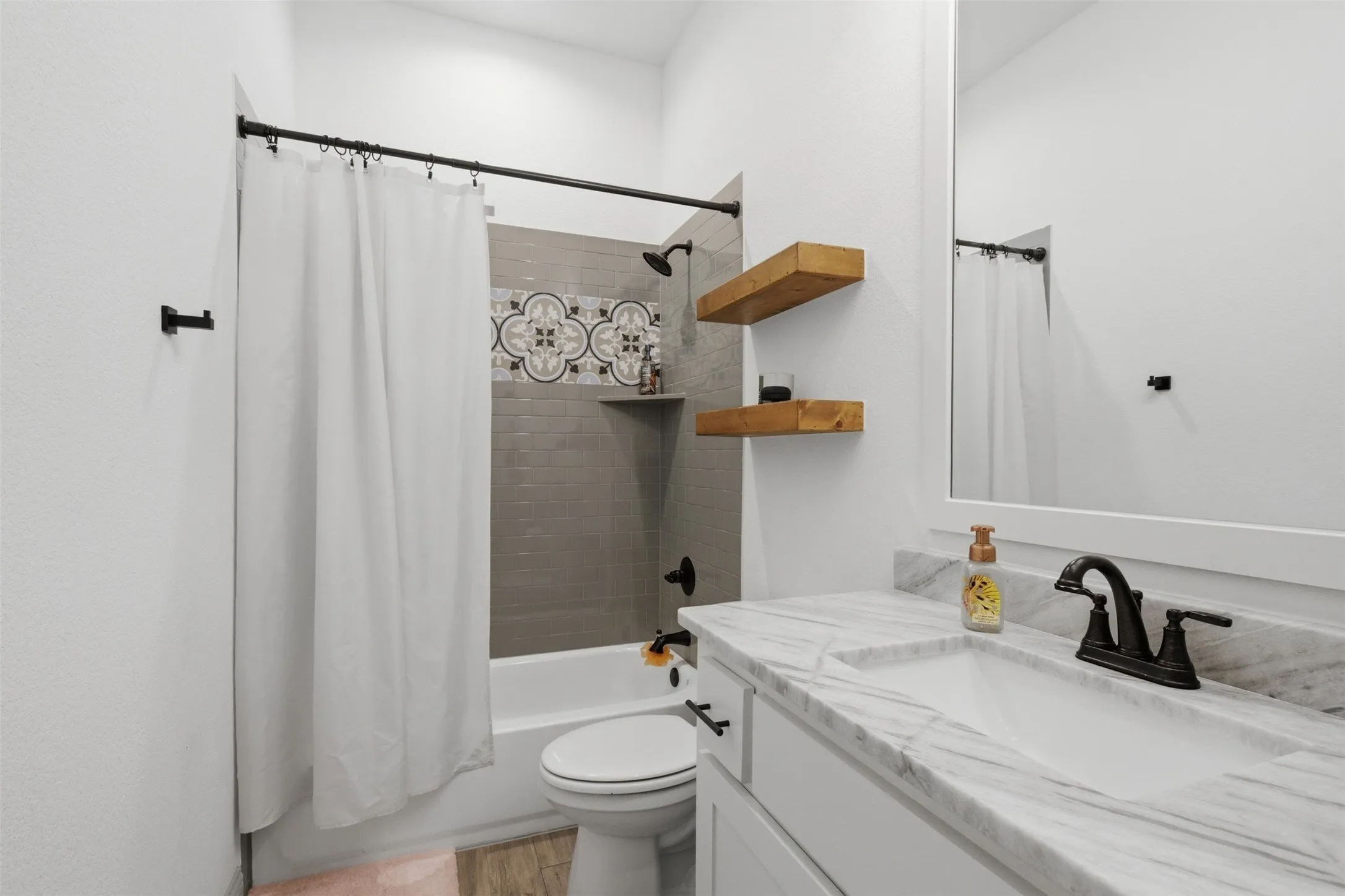 Shared full bath with tub/shower combo, decorative tile