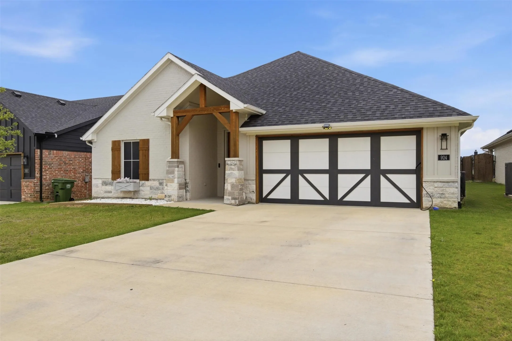 Single door on 2 car garage, stained wood beam detail welcome you home!