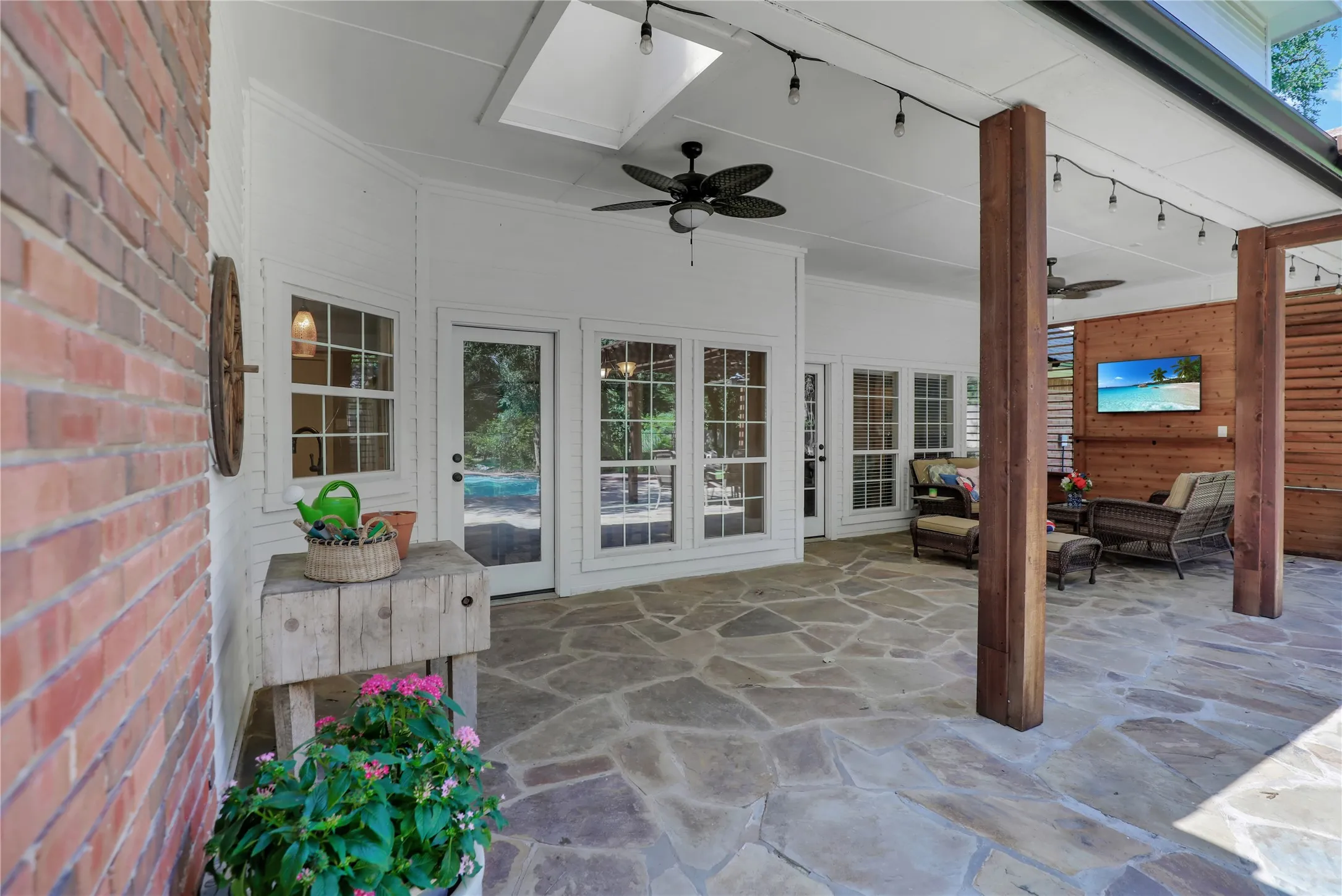 Covered natural stone patio with outdoor living area.