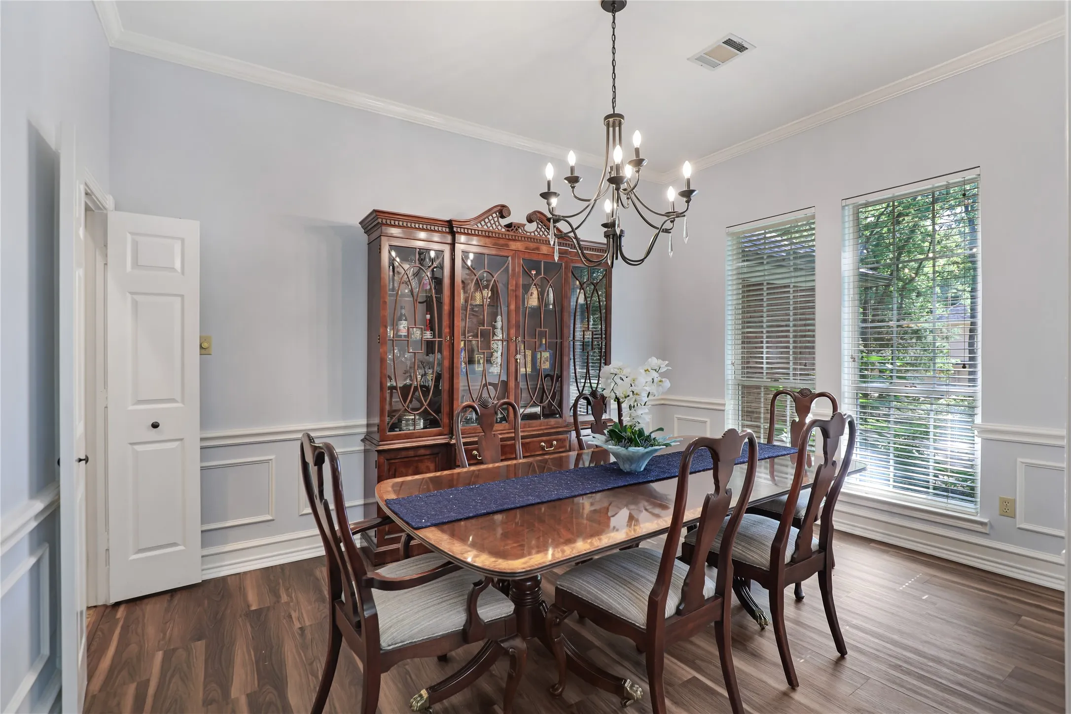 Formal dining room with chandelier and illuminated cabinet