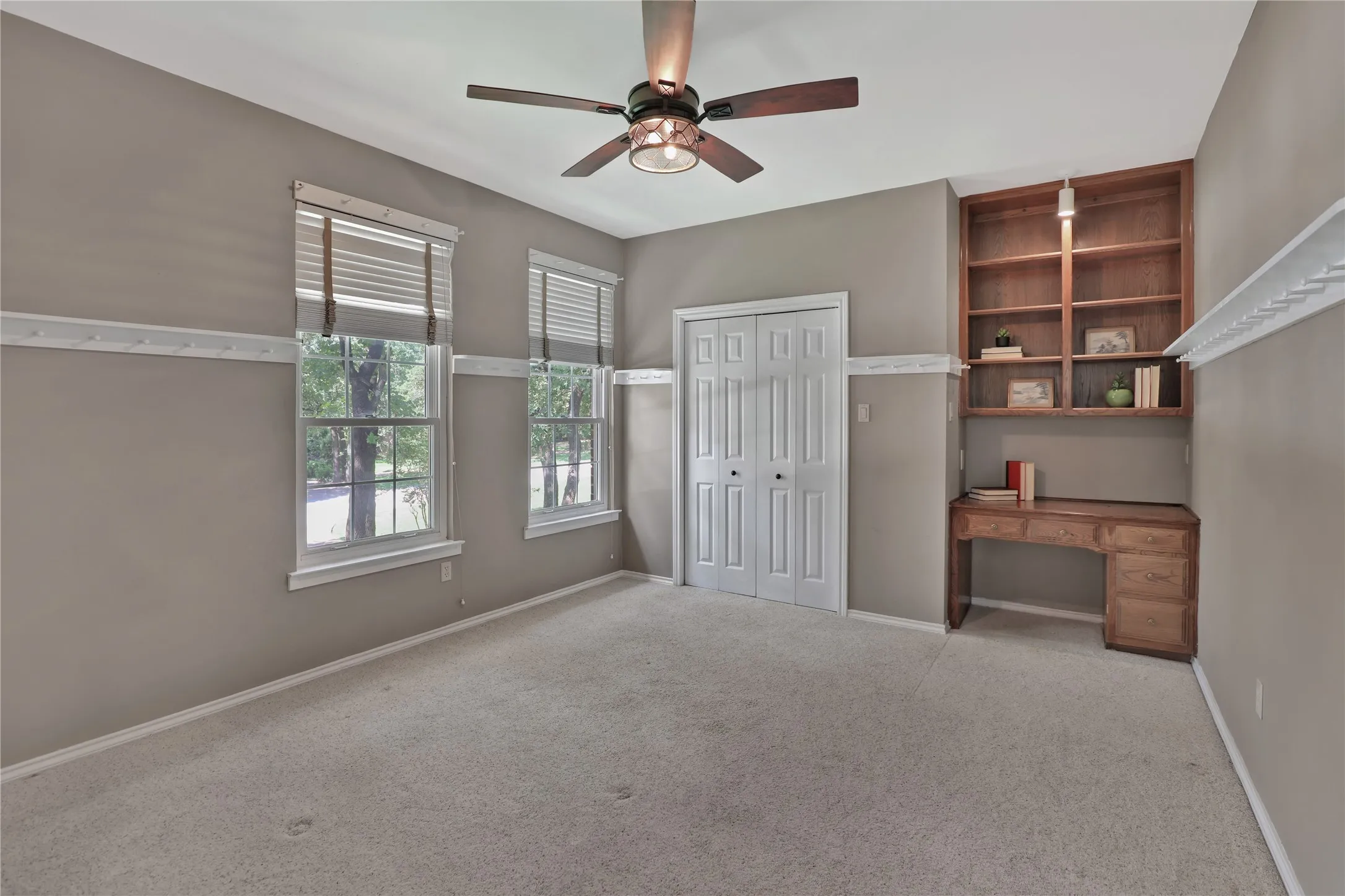 Bedroom with ceiling fan, built-in desk and walk-in closet
