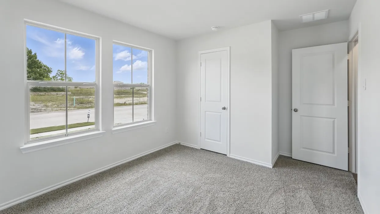 Bright room featuring two large windows, neutral gray carpet, white painted walls, and two white paneled doors
