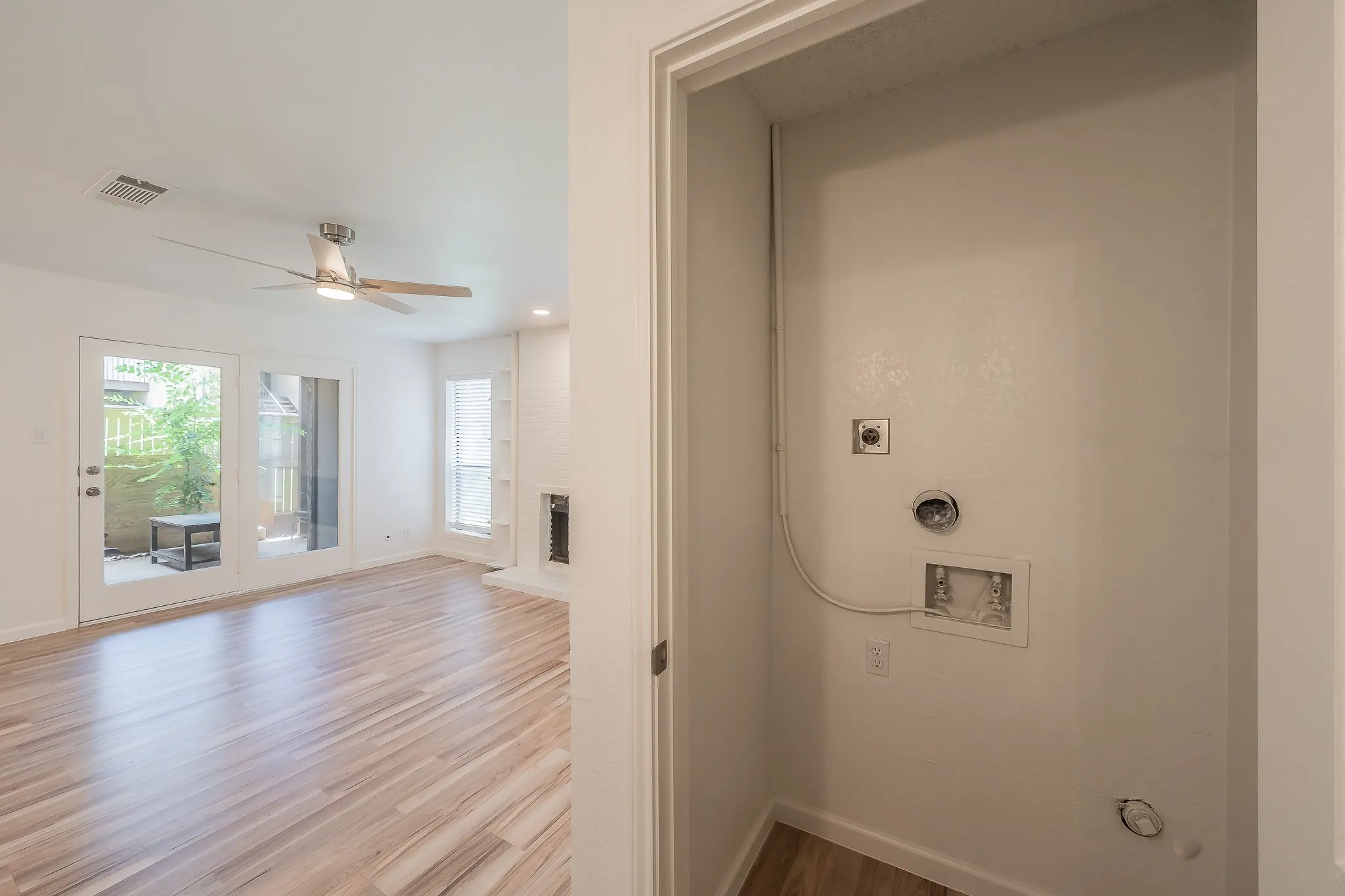 AI Staged bedroom featuring wood-finish flooring, a contemporary ceiling fan with wood-tone blades, a large window with blinds, and recessed lighting