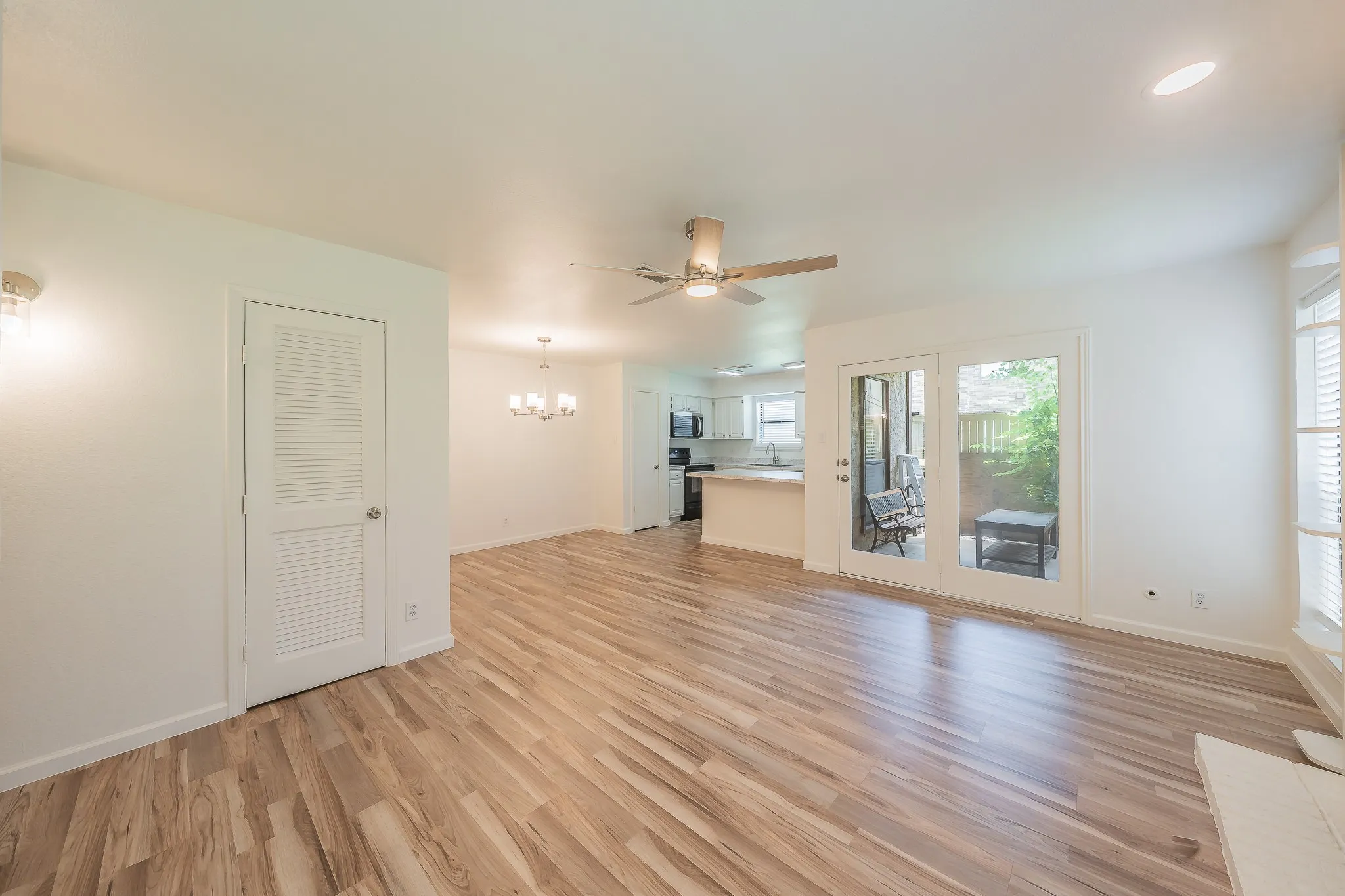 Spacious living area featuring wood-finish flooring, new ceiling fan, and recessed lighting