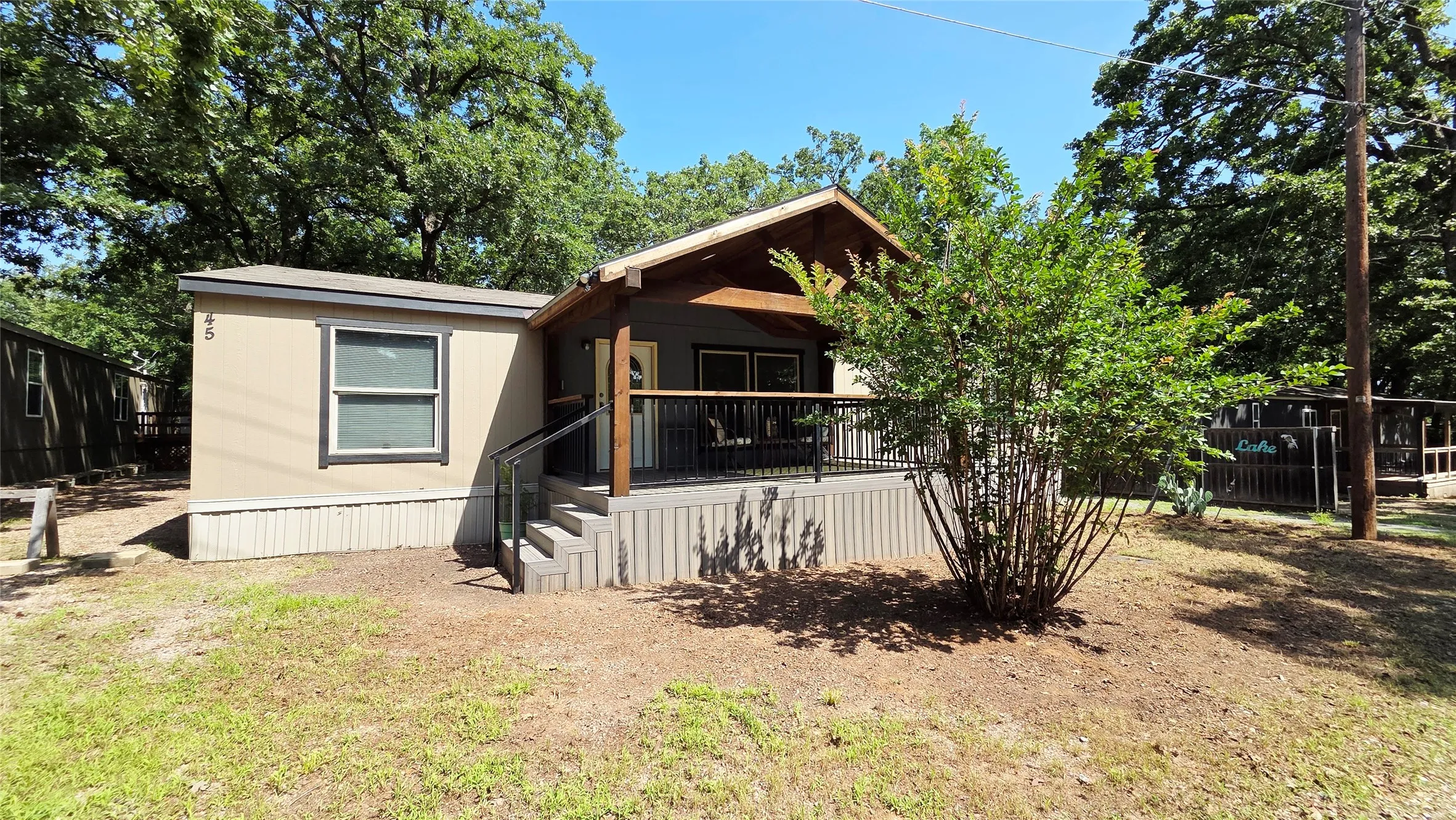 Single-story residence featuring a covered front porch with dark wood posts and a metal railing