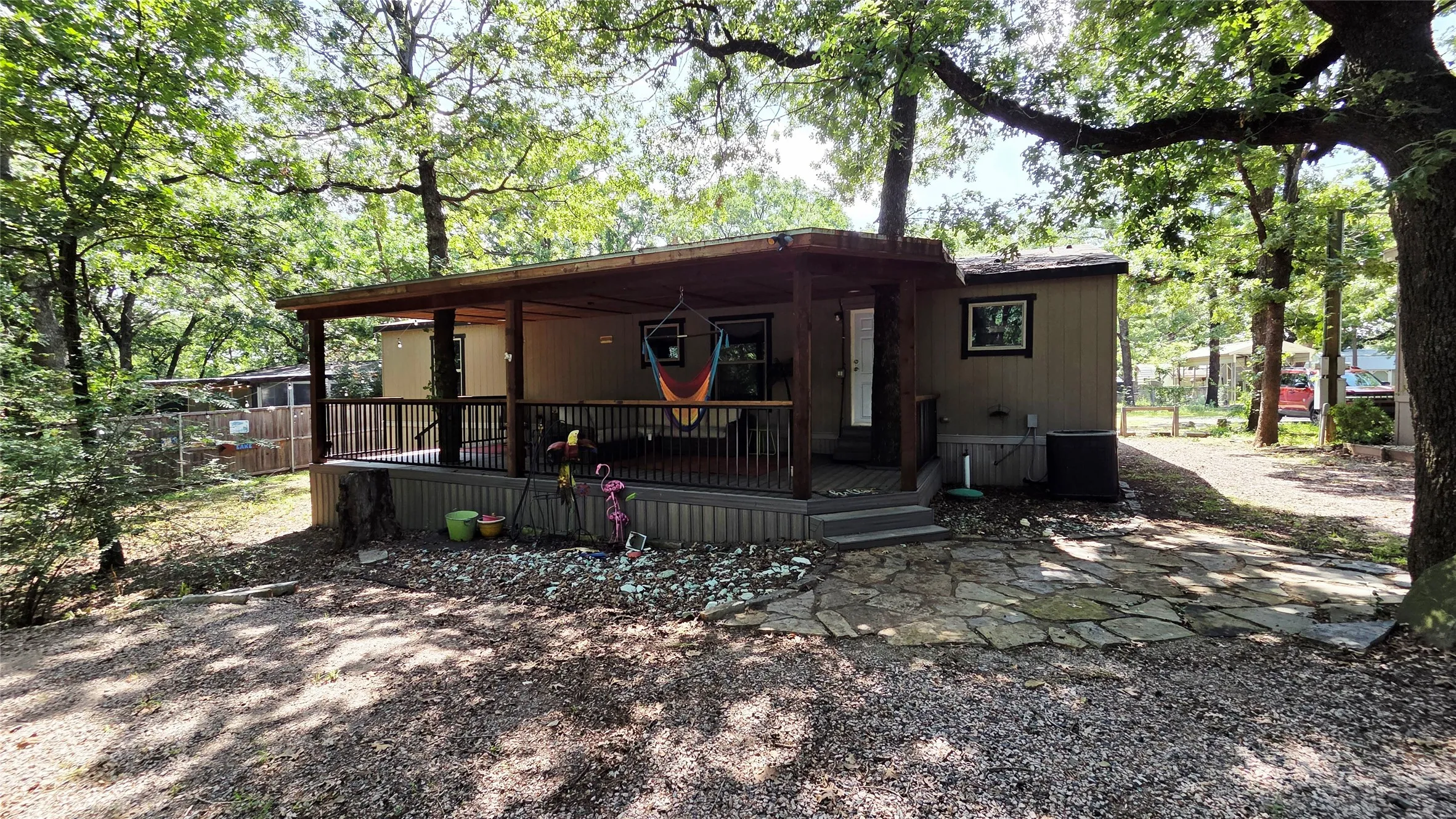 Covered front porch with dark wood railing and steps